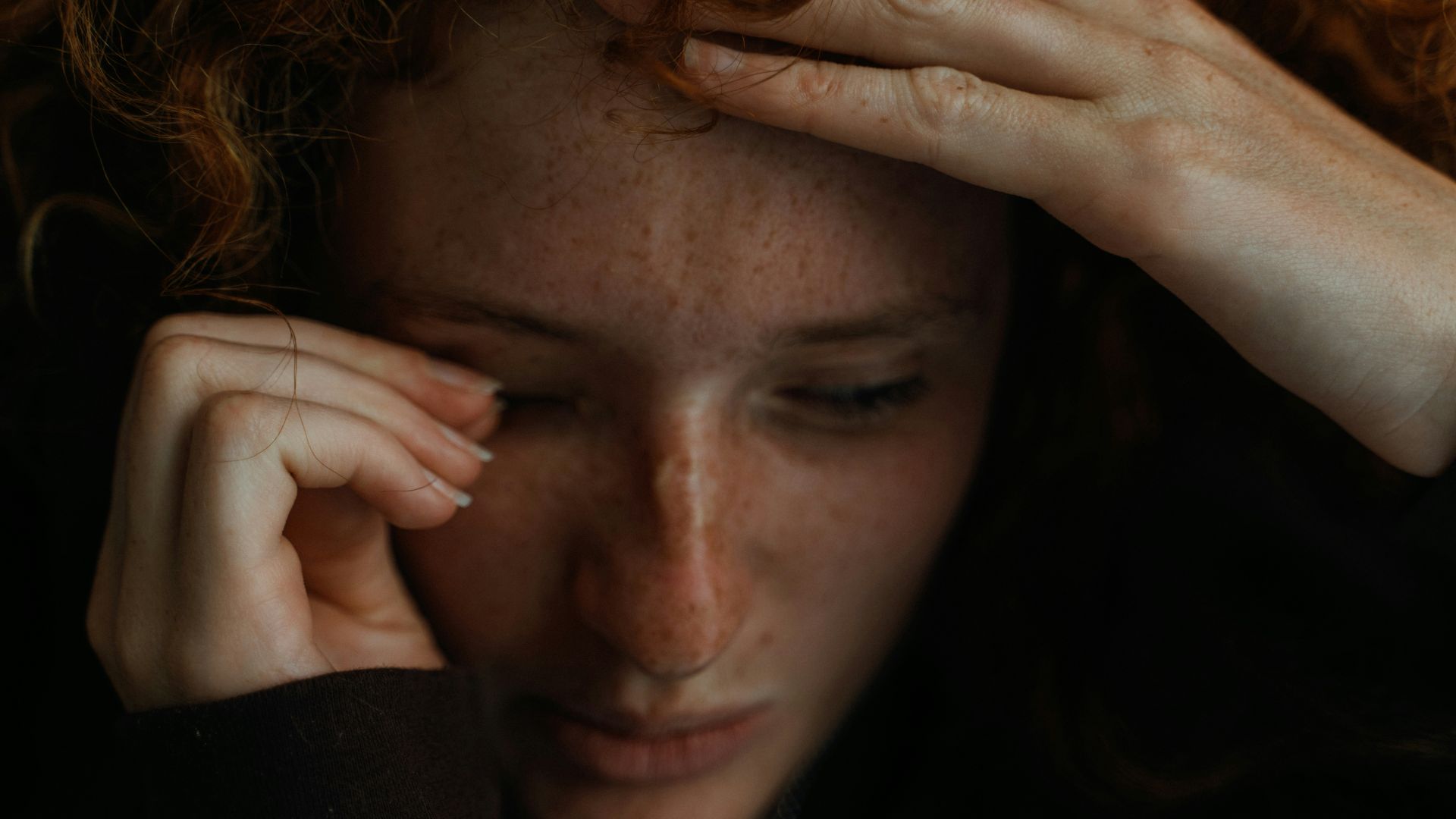 a close up of a person holding their head
