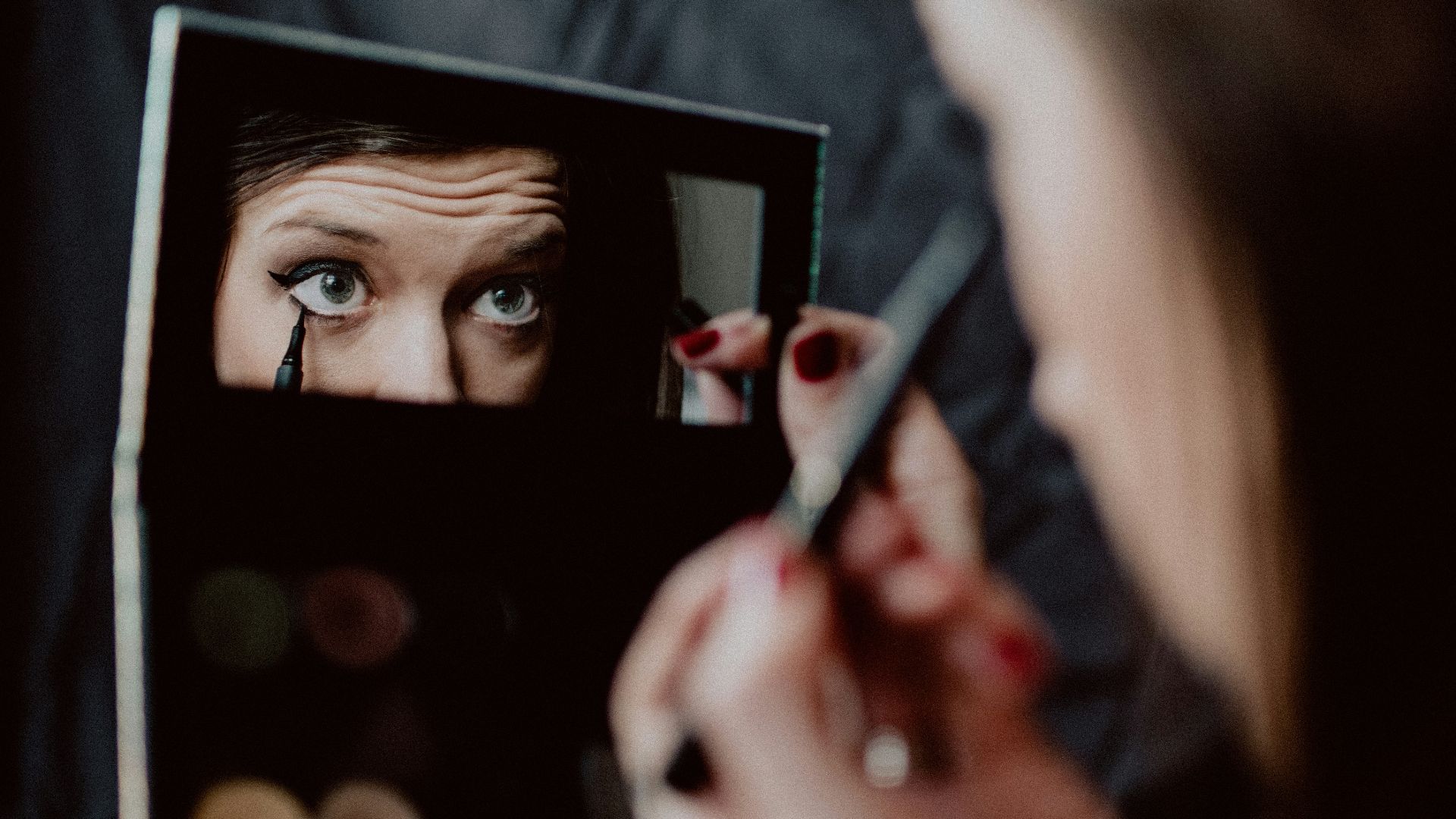 woman holding black framed mirror
