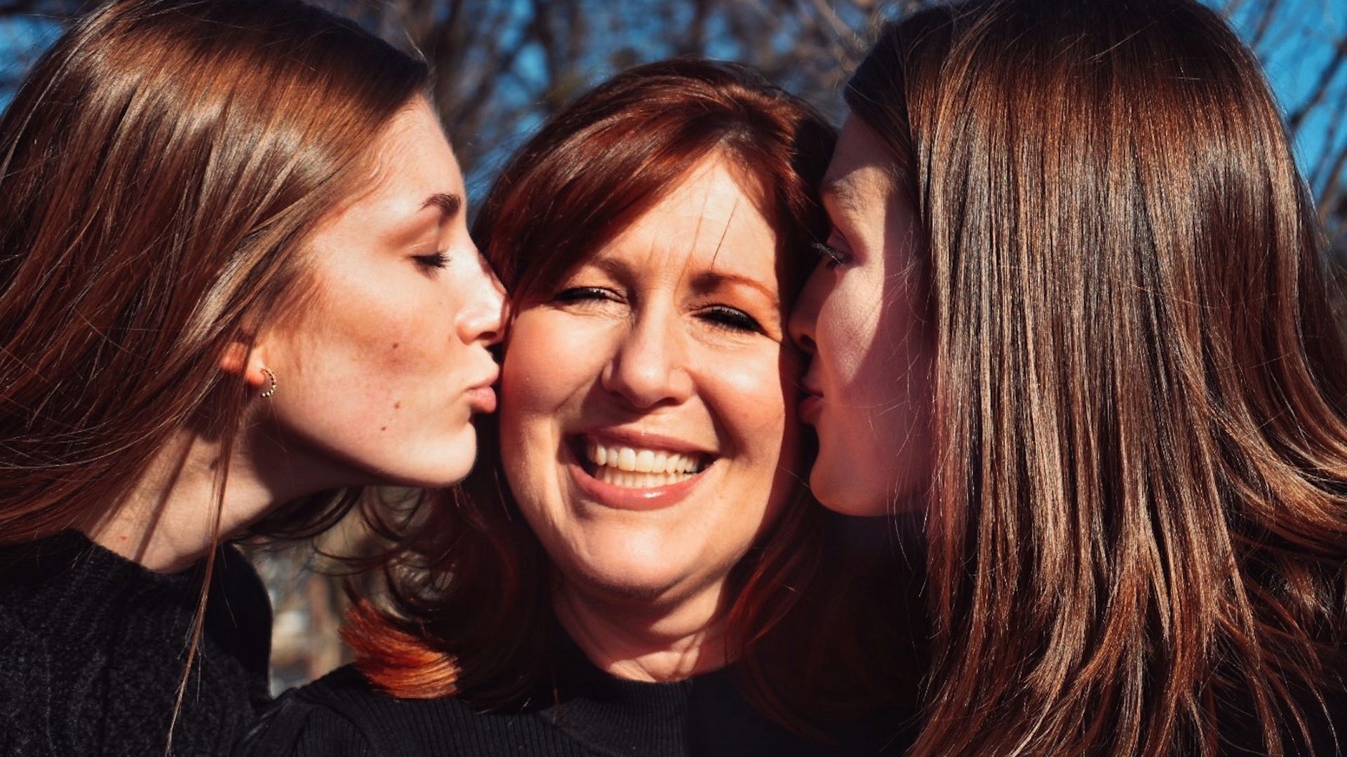 woman in black turtleneck shirt smiling beside woman in black shirt