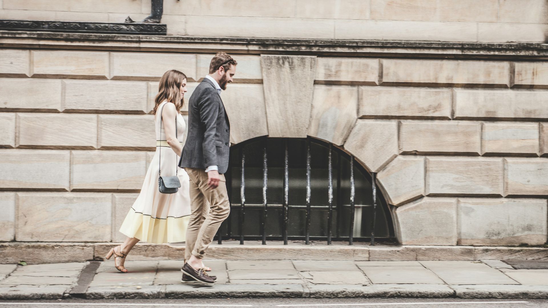man and woman walking beside a road during daytime