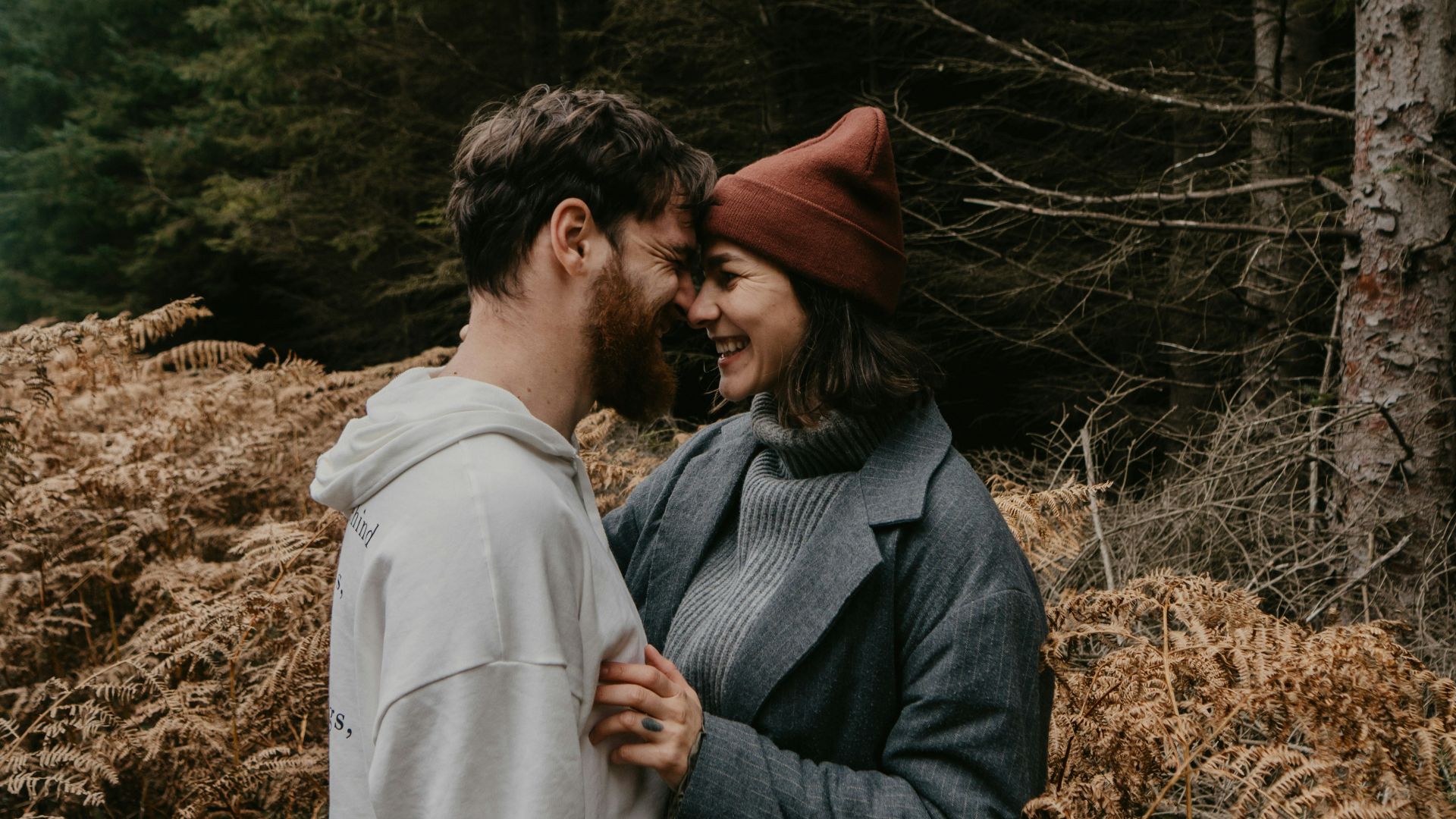 man and woman kissing on brown grass field during daytime