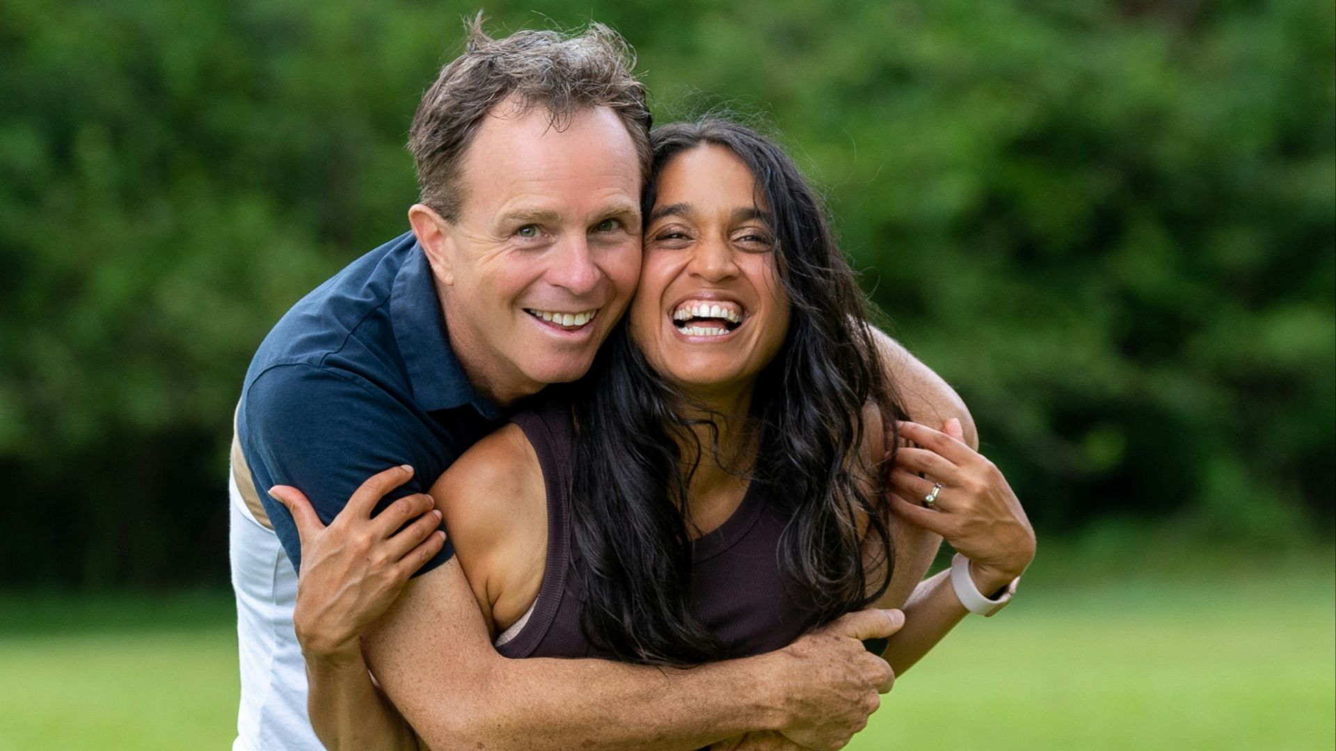 a man hugging a woman in a field