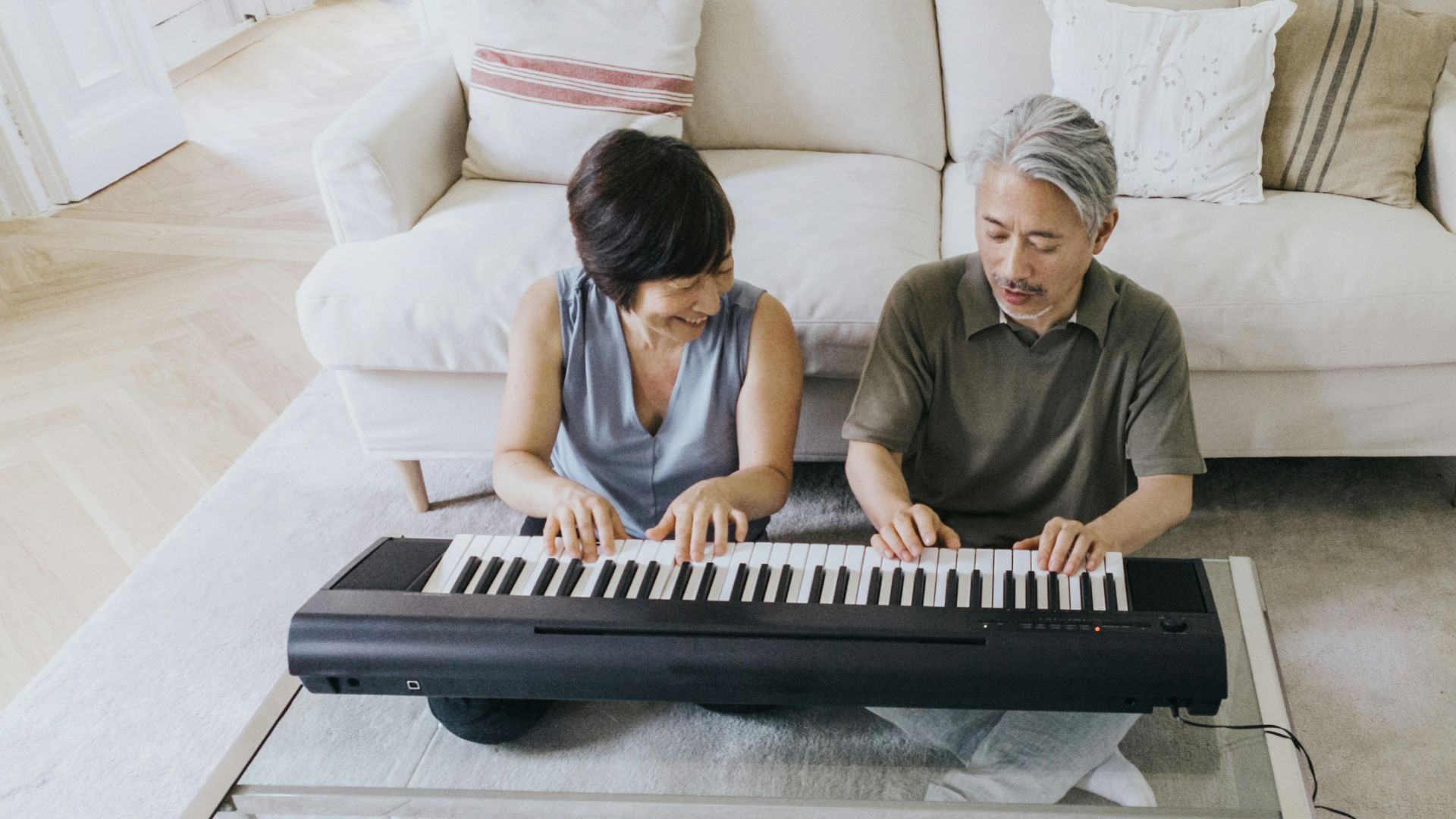 a man and a woman playing a piano on a couch