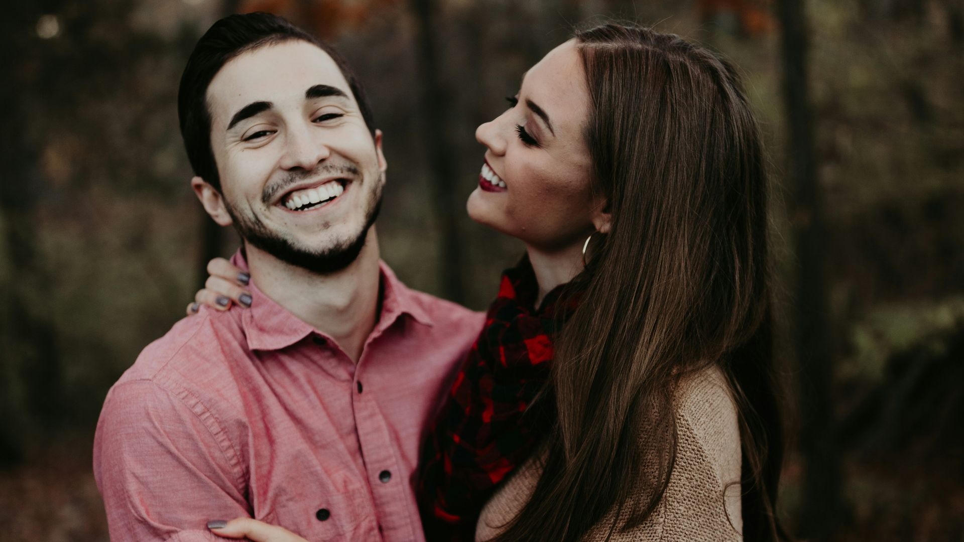 woman hugging man selective focus photography