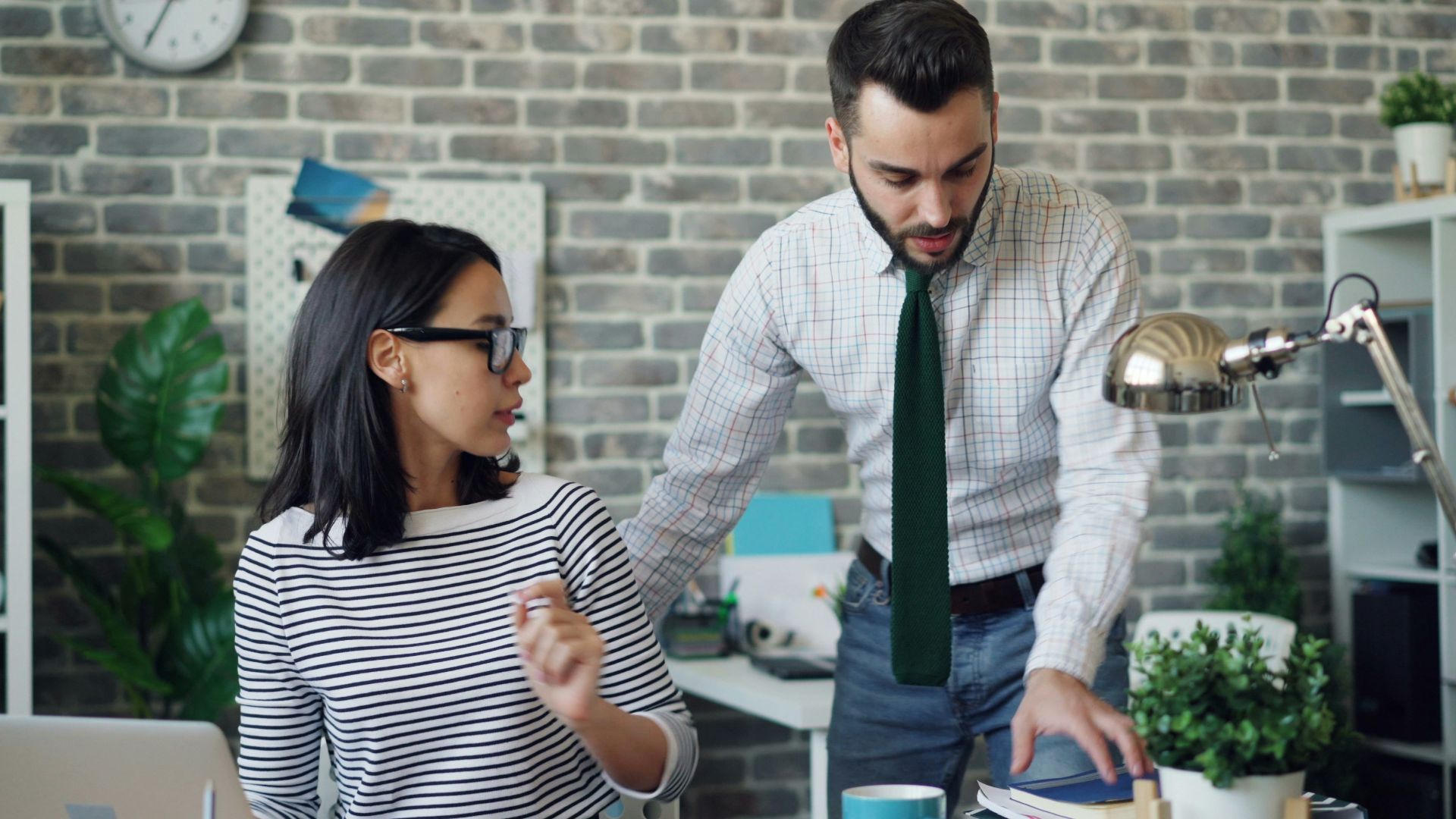 a man and a woman standing in front of a laptop
