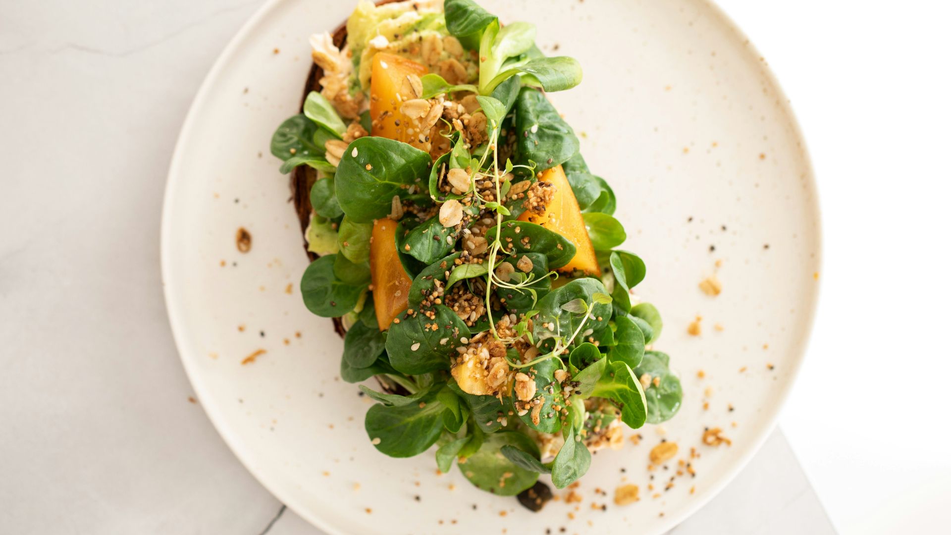 a white plate topped with a green salad