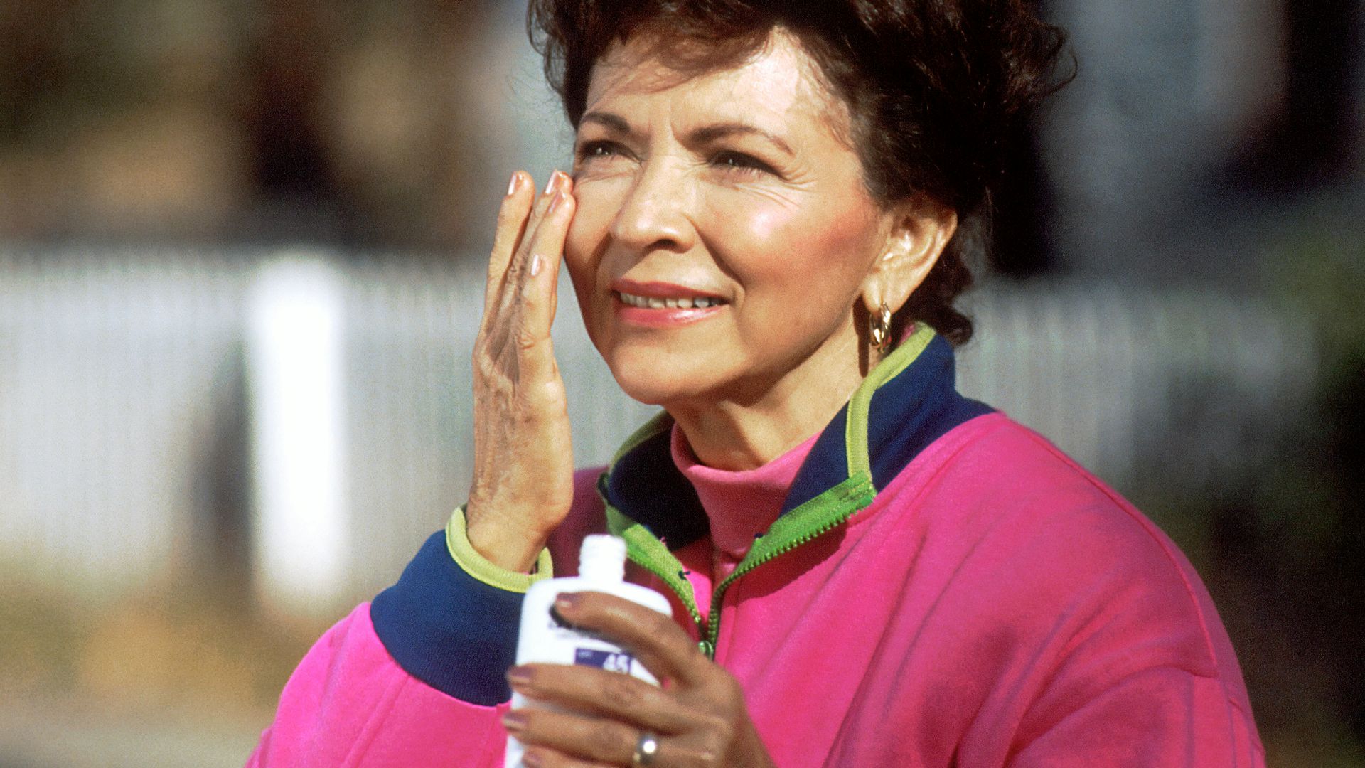 smiling woman in pink and blue shirt