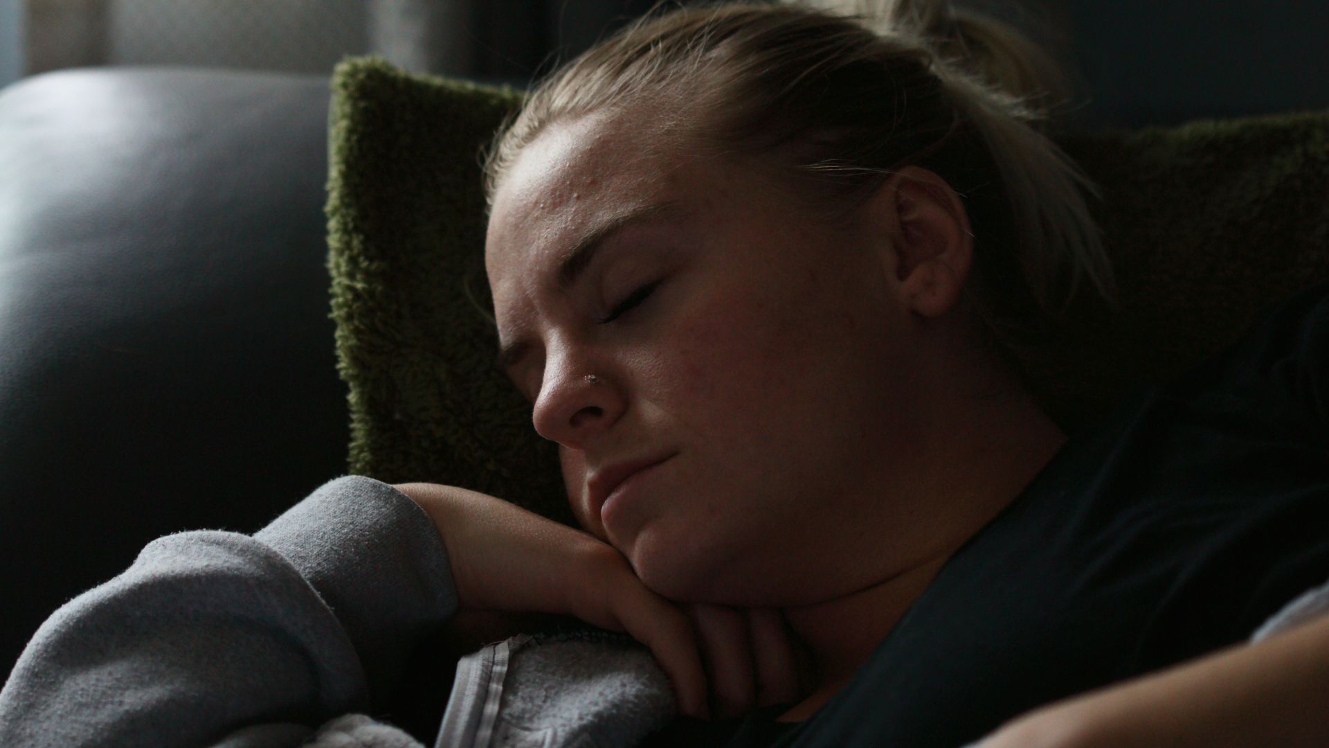 woman in black shirt lying on couch