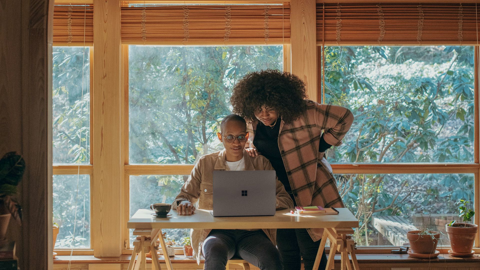 person sitting on chair in front of table with Surface device