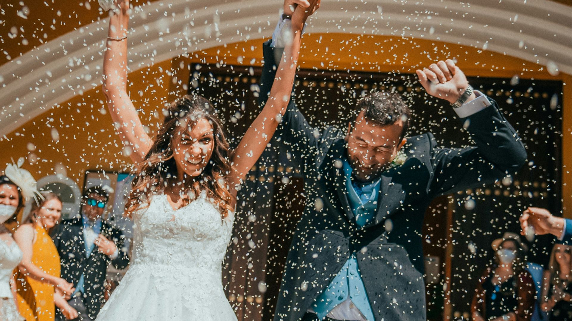 a bride and groom are dancing in the rain