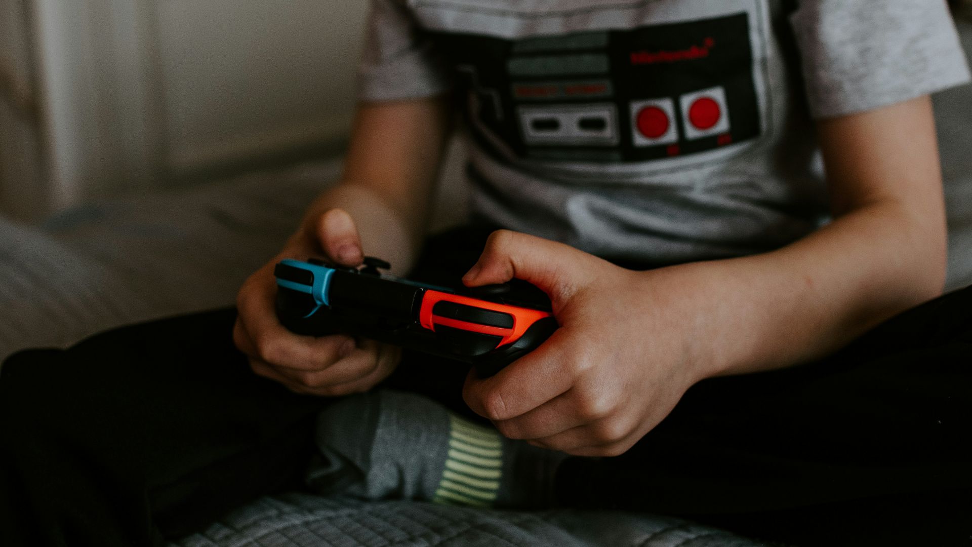 kid sitting on gray bed while playing
