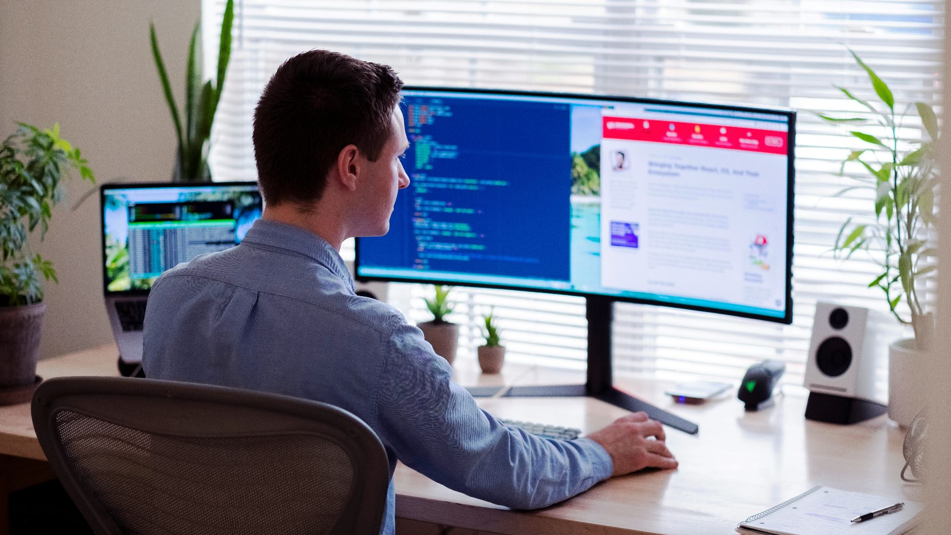 man in gray dress shirt sitting on chair in front of computer monitor
