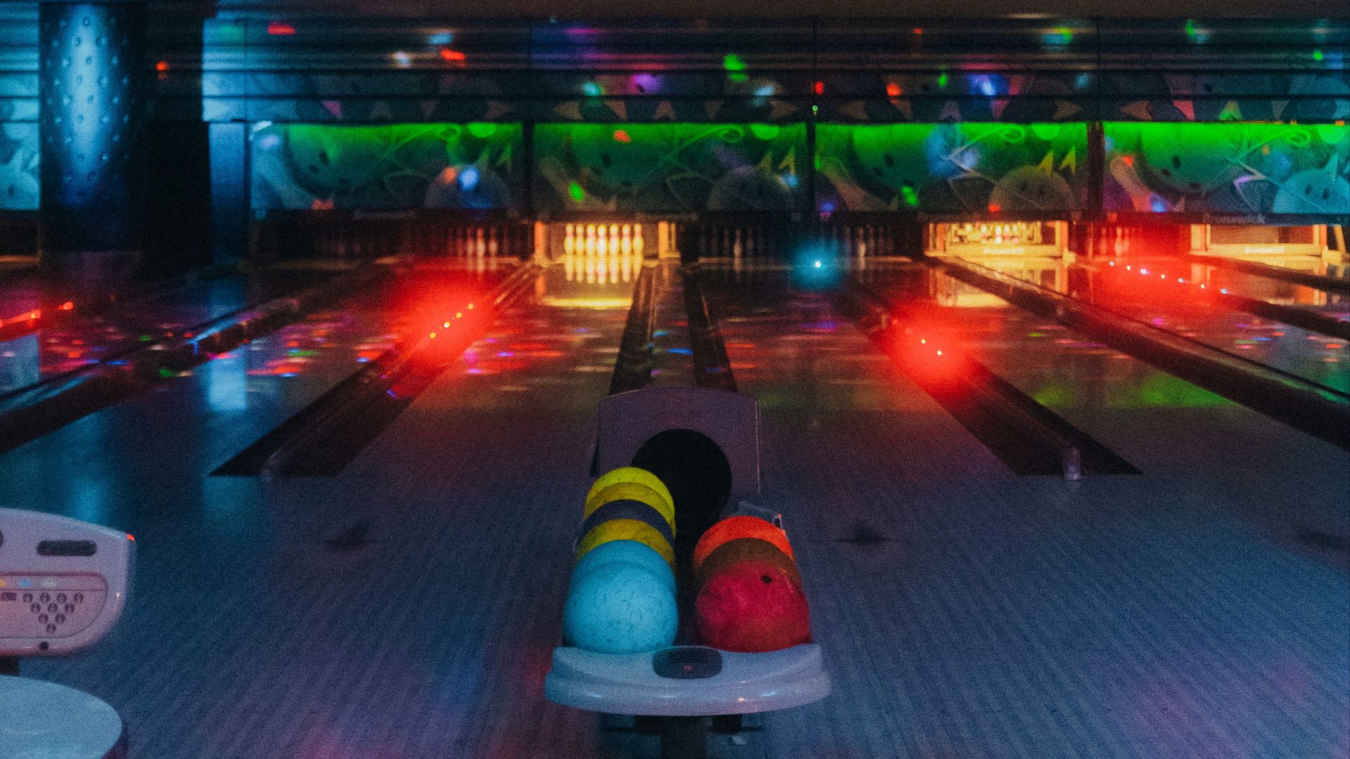 a bowling alley filled with bowling balls and neon lights