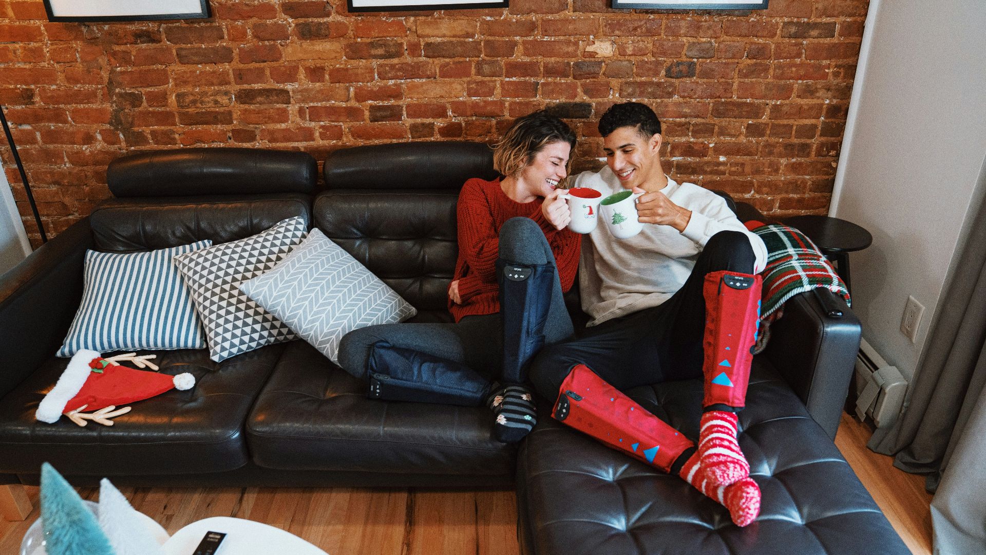 a man and a woman sitting on a couch with a santa clause garment