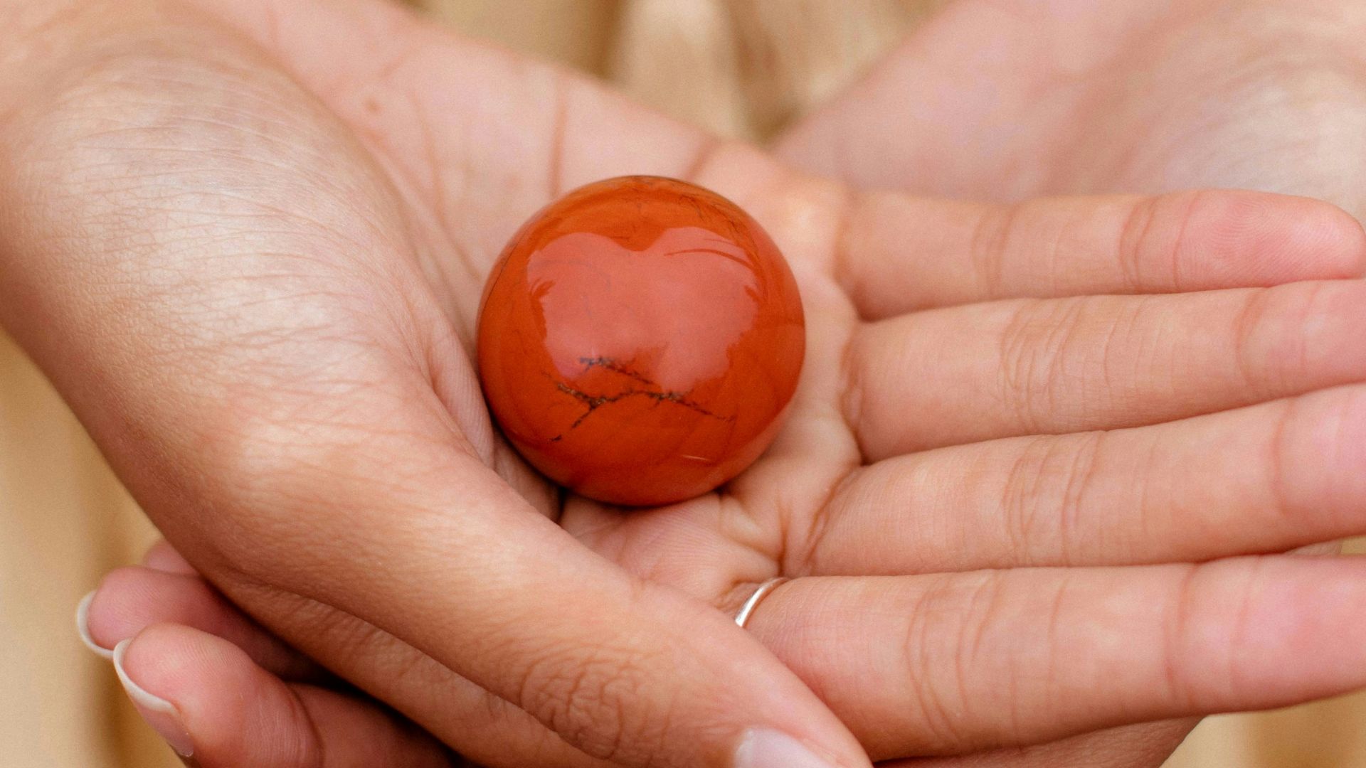 a hand holding a small orange ball