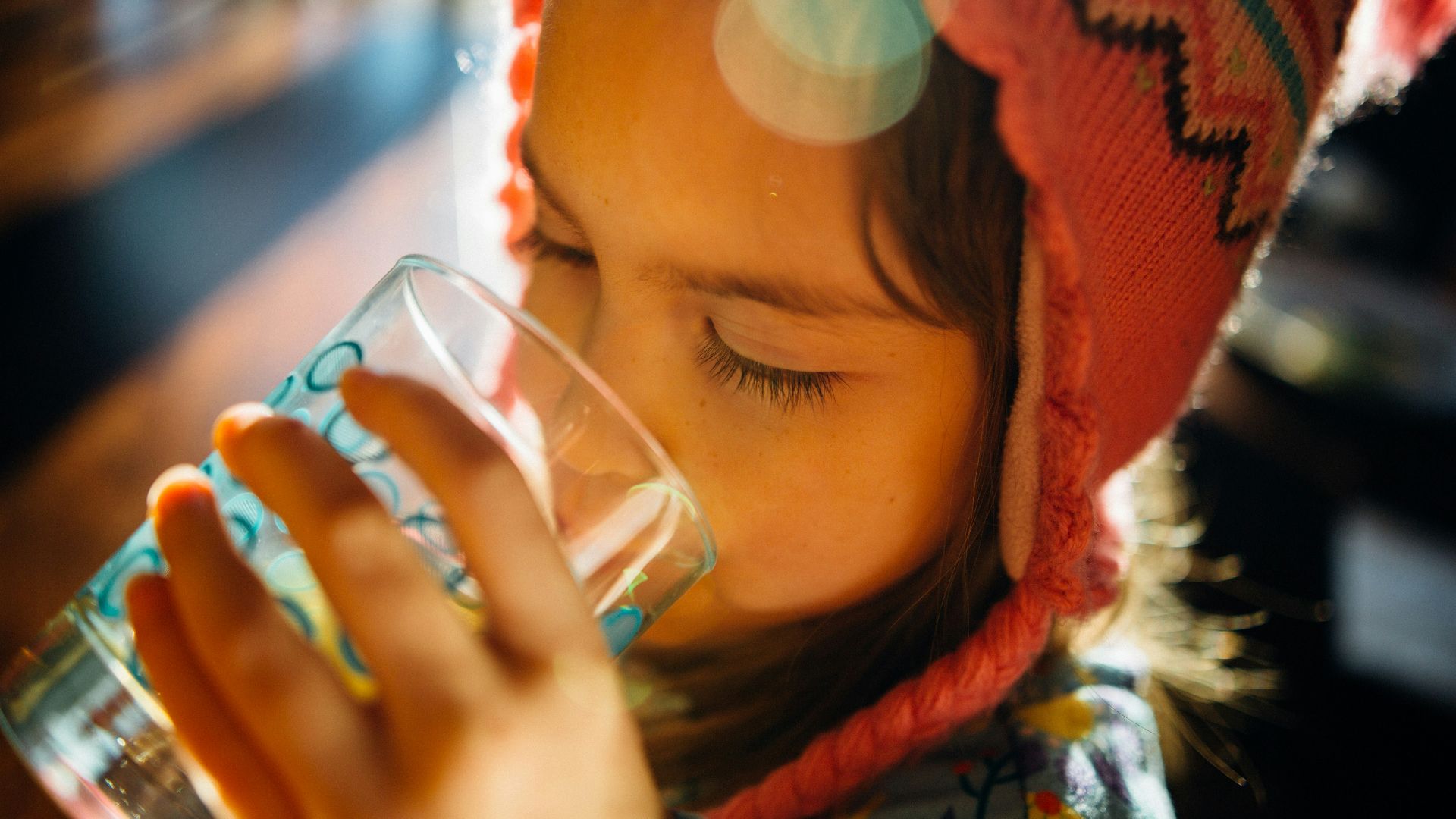selective focus photography of girl drinking water