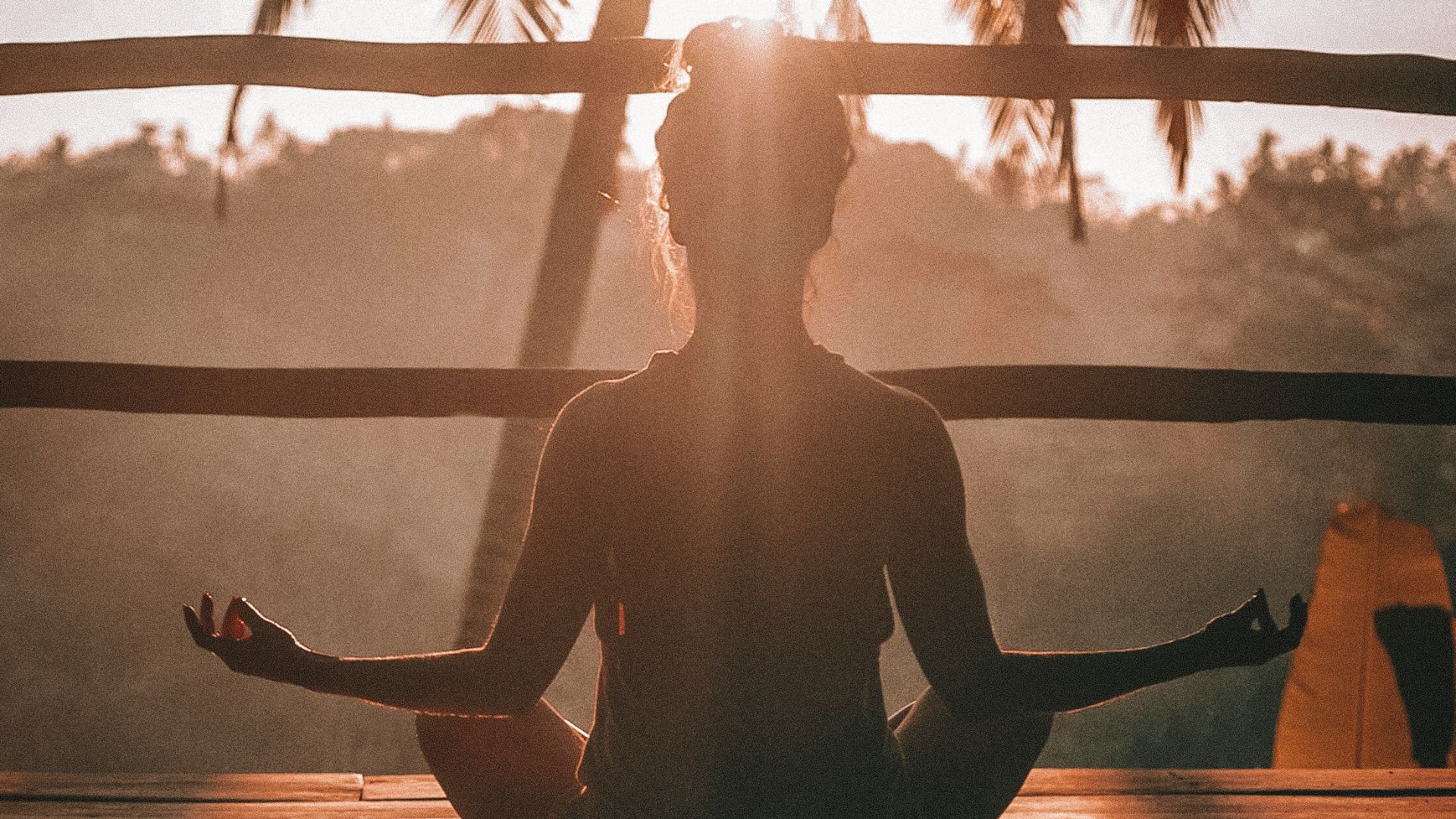 woman doing yoga meditation on brown parquet flooring