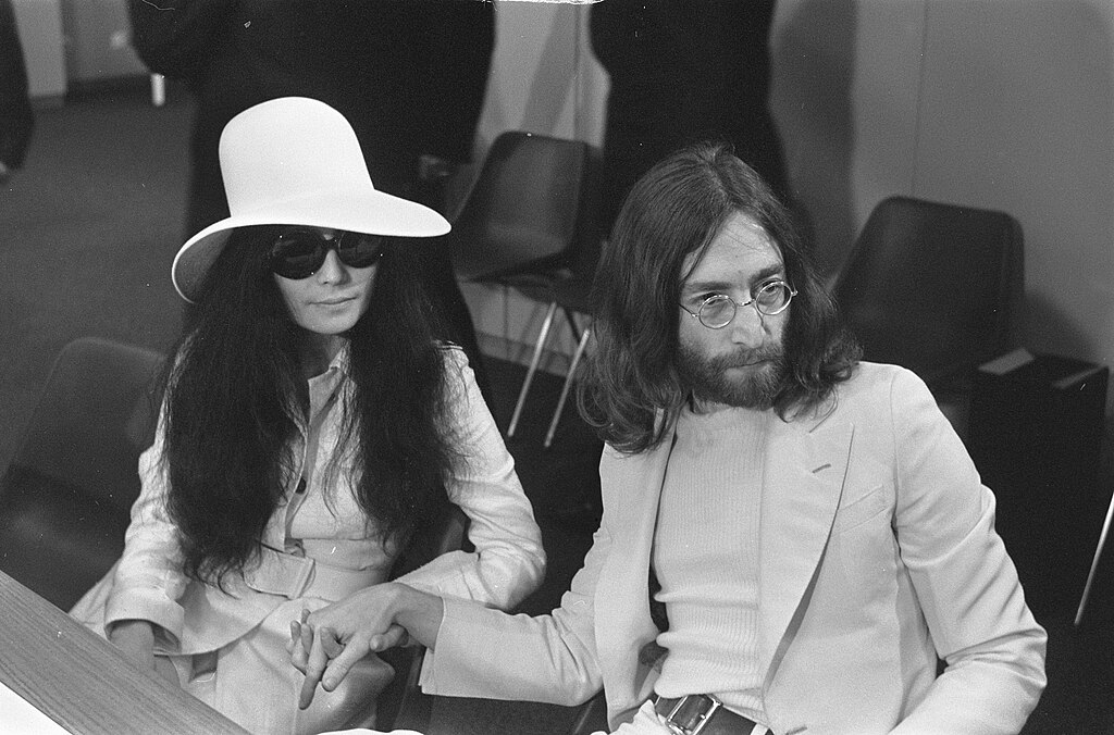 1024Px-John Lennon En Echtgenote Yoko Ono Vertrekken Van Schiphol Naar Wenen In De Vert, Bestanddeelnr 922-2499