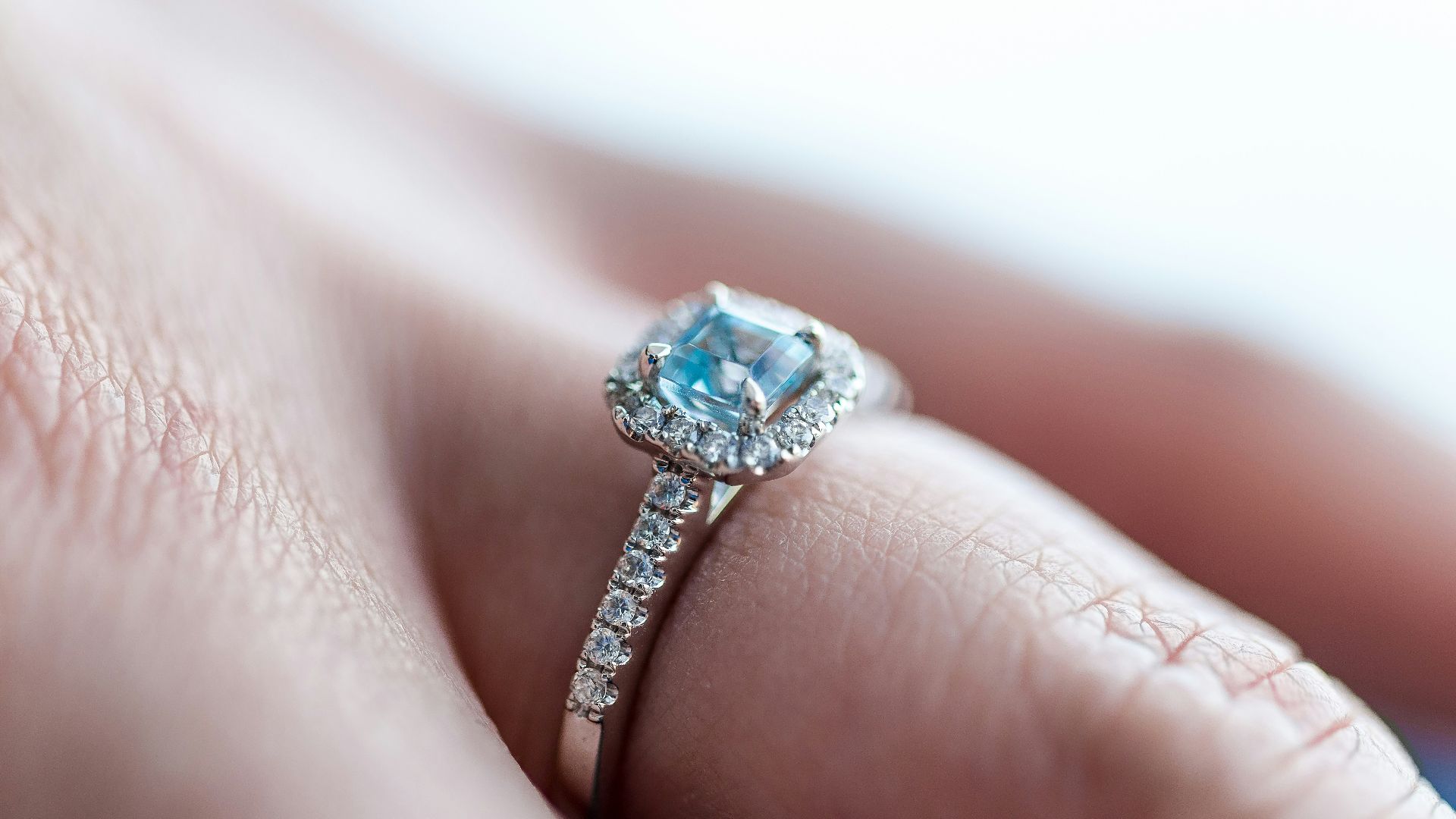 person showing silver-colored ring with gemstone