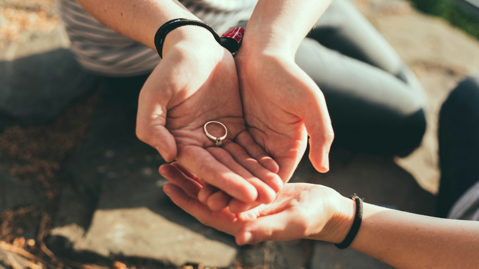 person giving ring to another hand during daytime