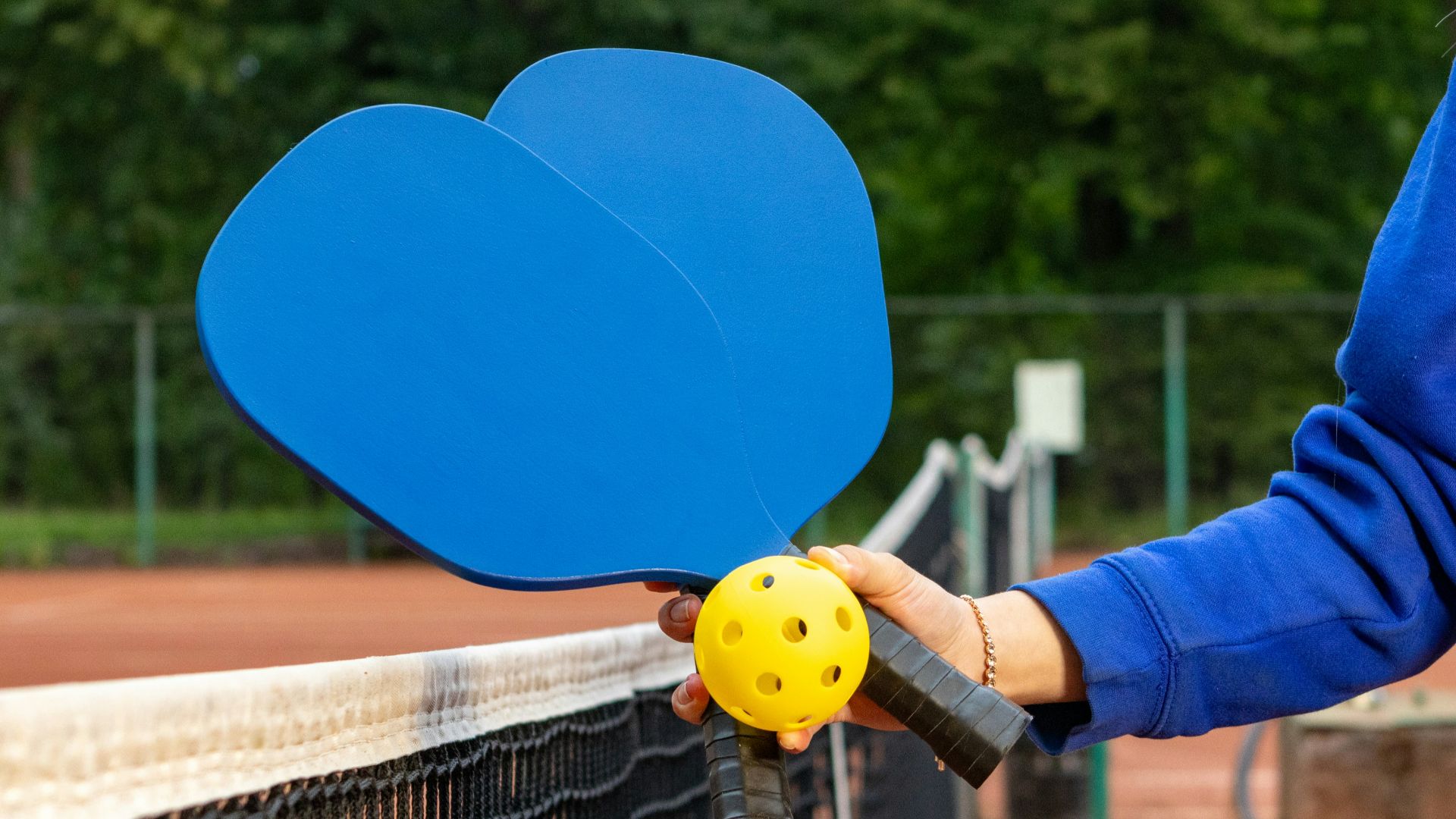 a person holding a tennis racket and a ball