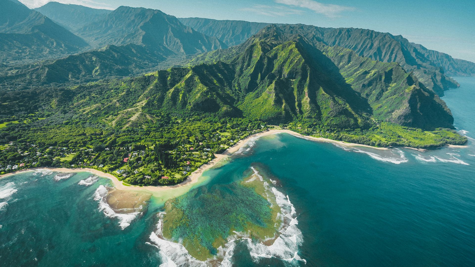 aerial view of green and brown mountains and lake