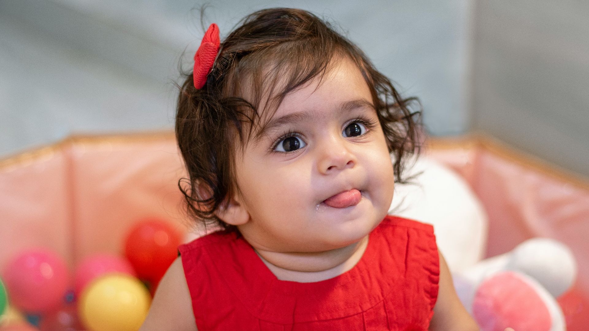 a little girl sitting in a ball pit