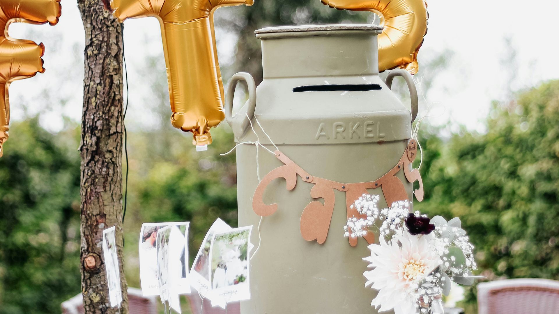 a table topped with a vase filled with gold balloons