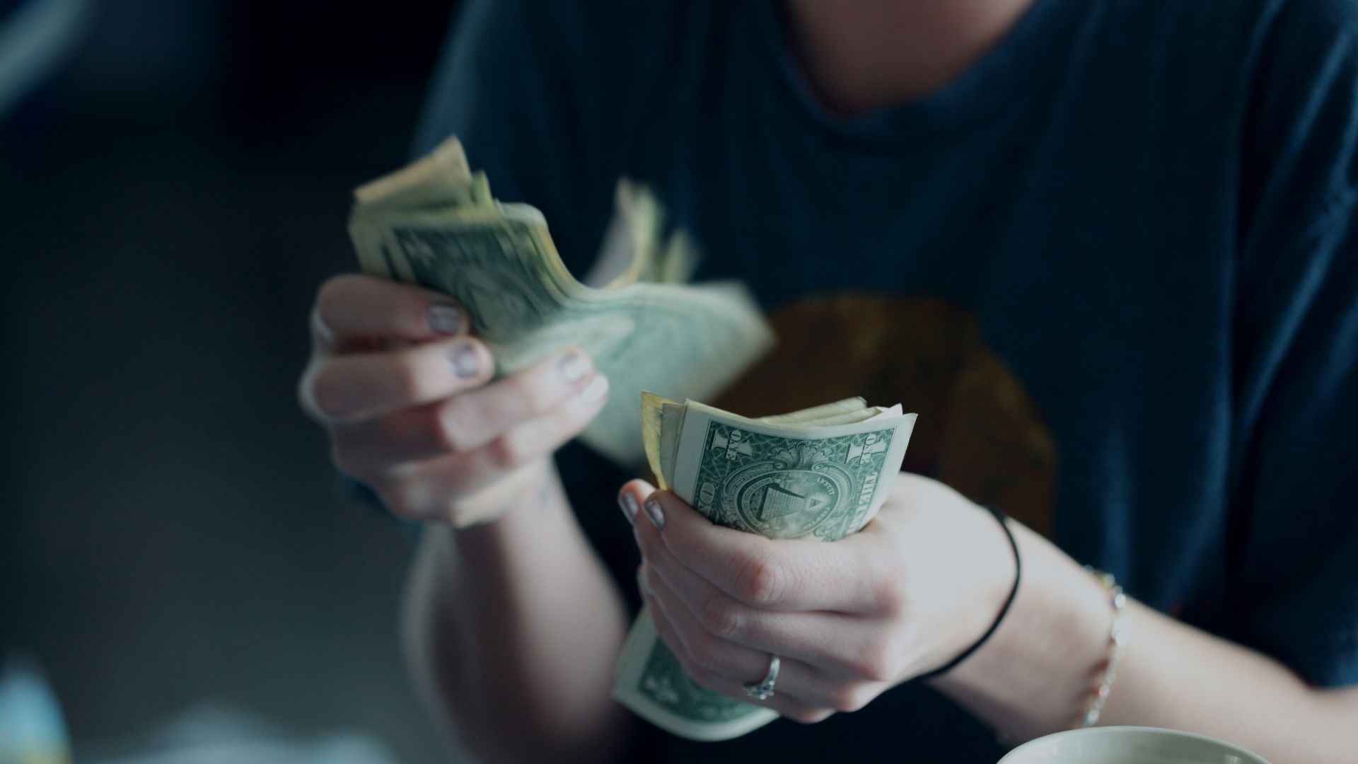 focus photography of person counting dollar banknotes