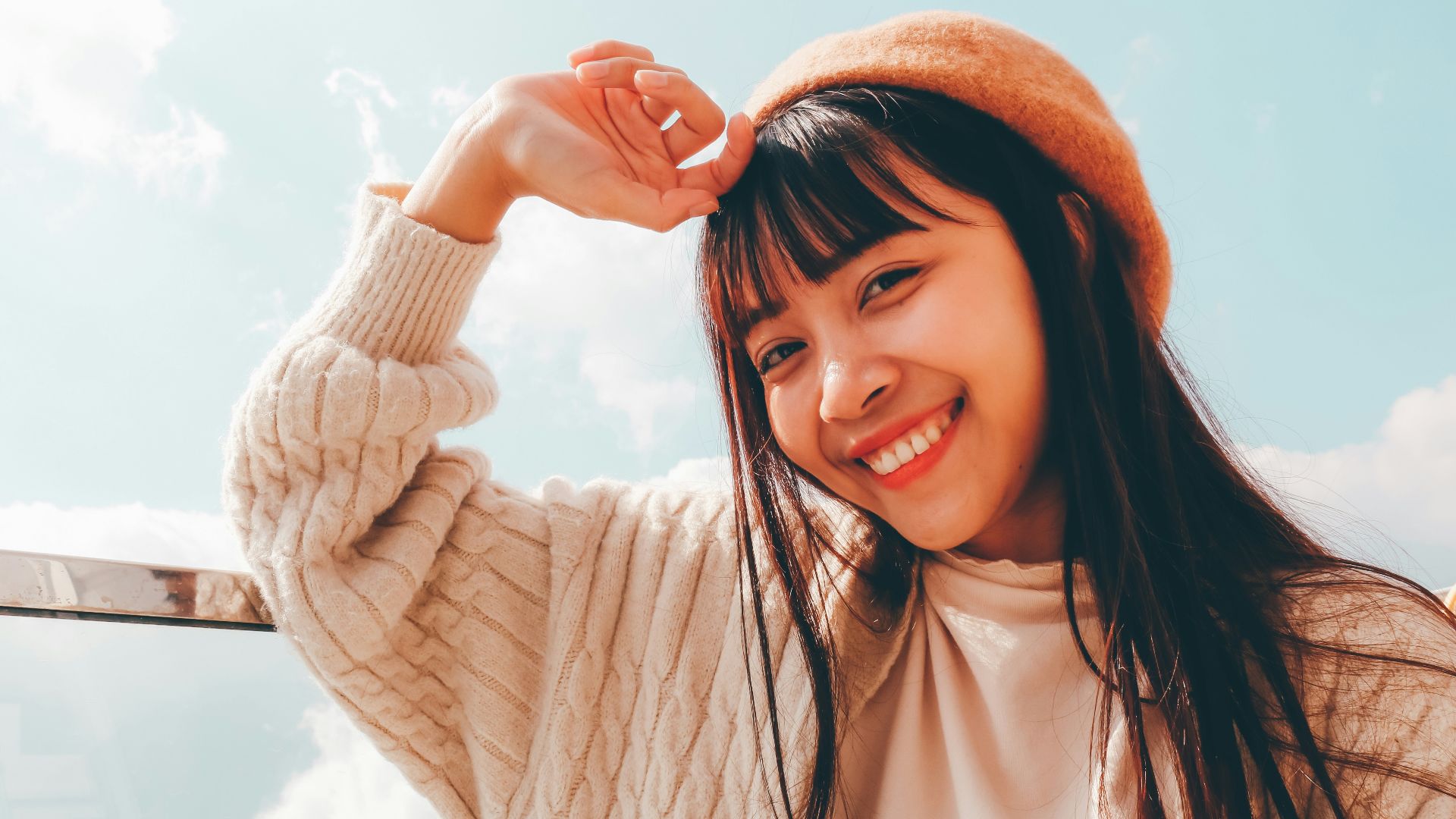 woman in white long sleeve shirt and orange knit cap