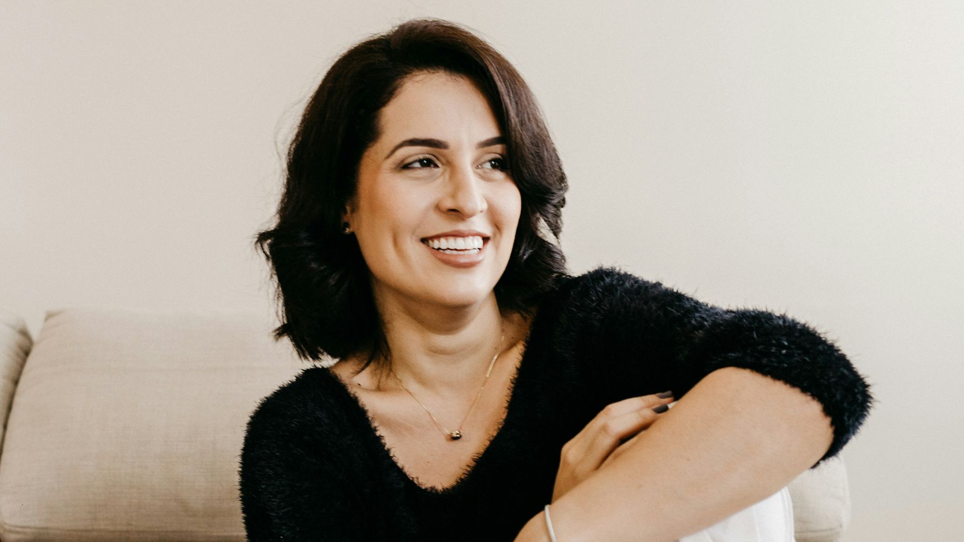 woman in black long sleeve shirt sitting on white couch