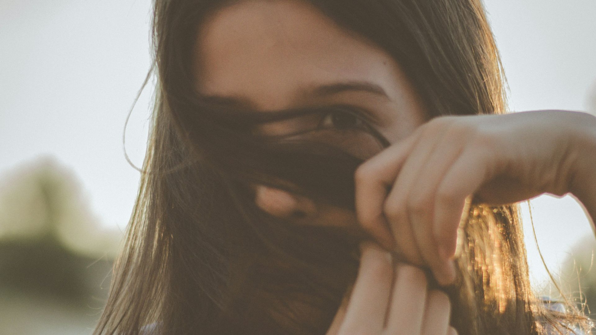 man covering her face with her hair
