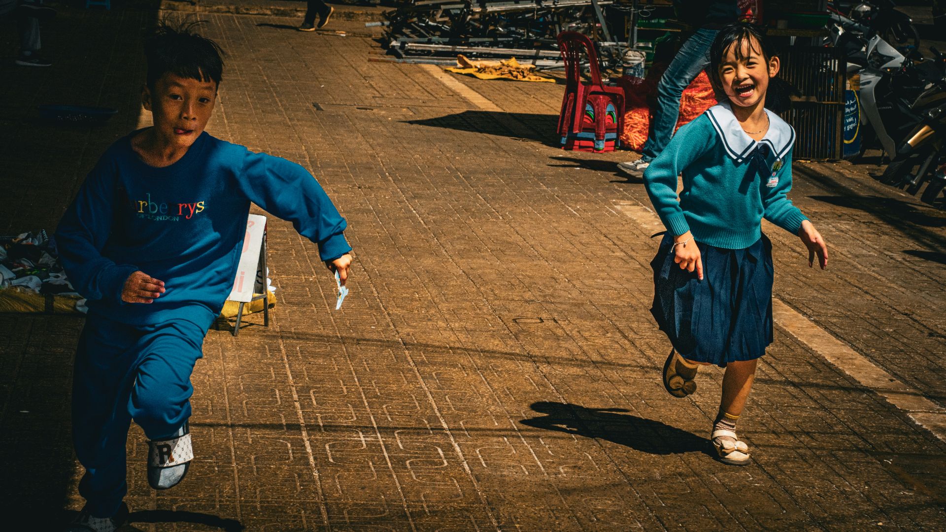 A couple of kids running down a street