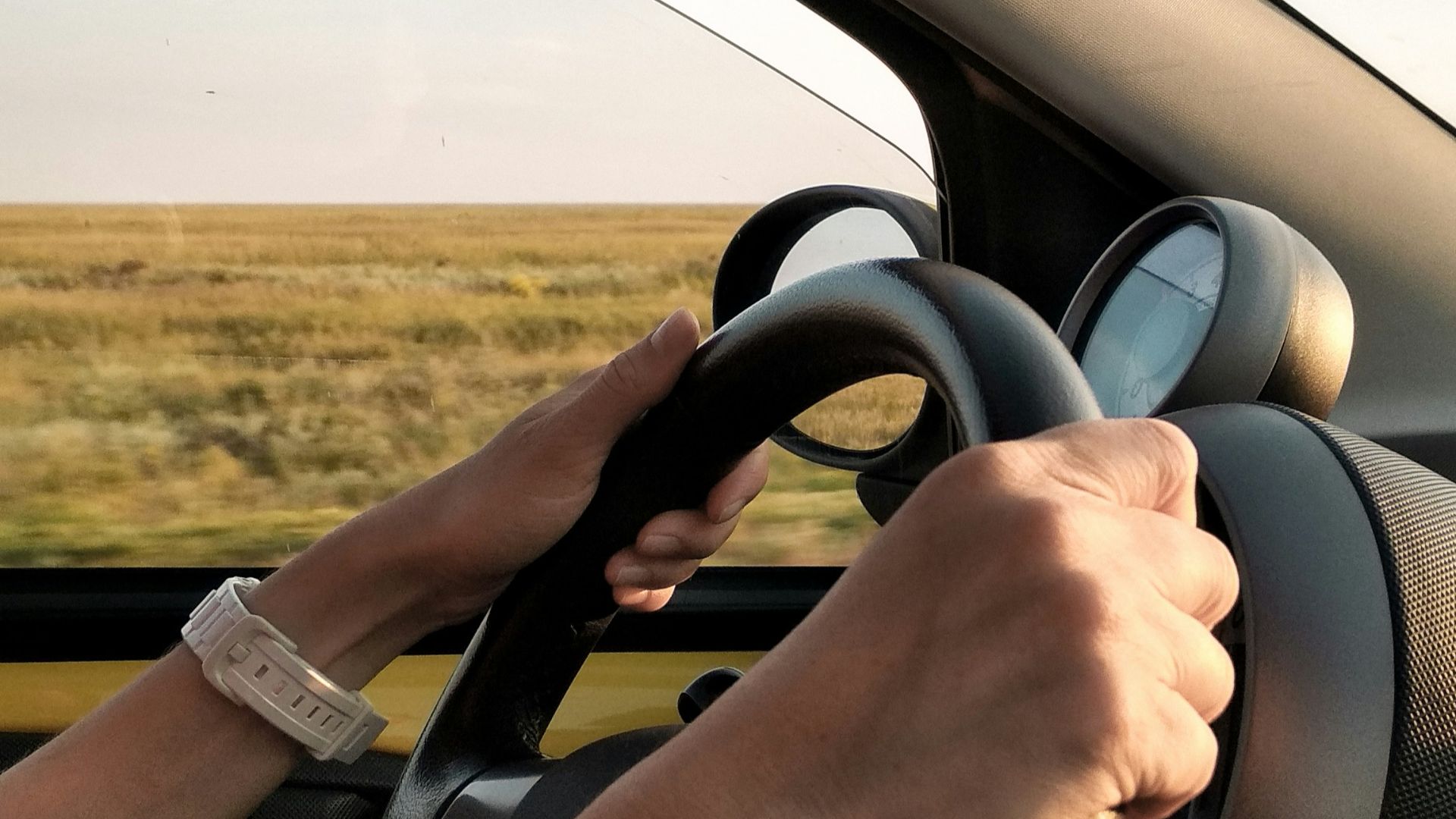 person with white watch driving car