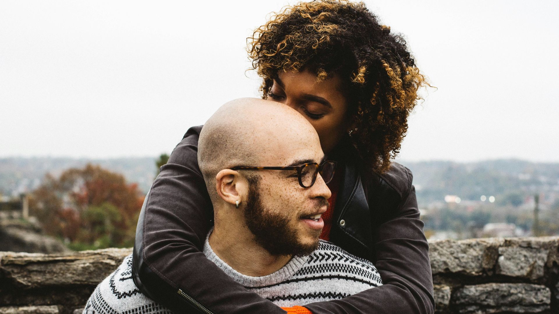 woman kissing man's head