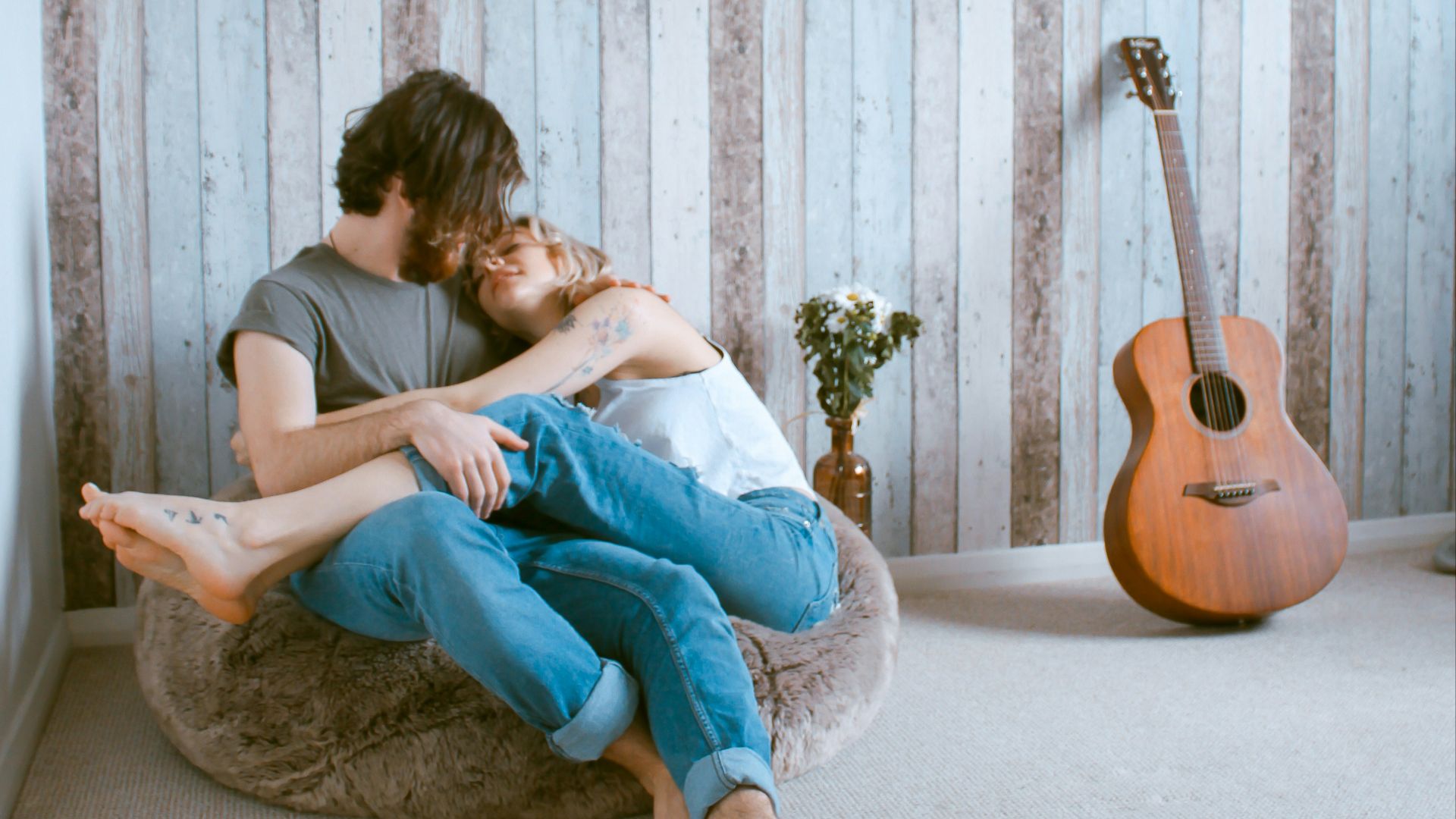 man and woman sitting on gray beanbag
