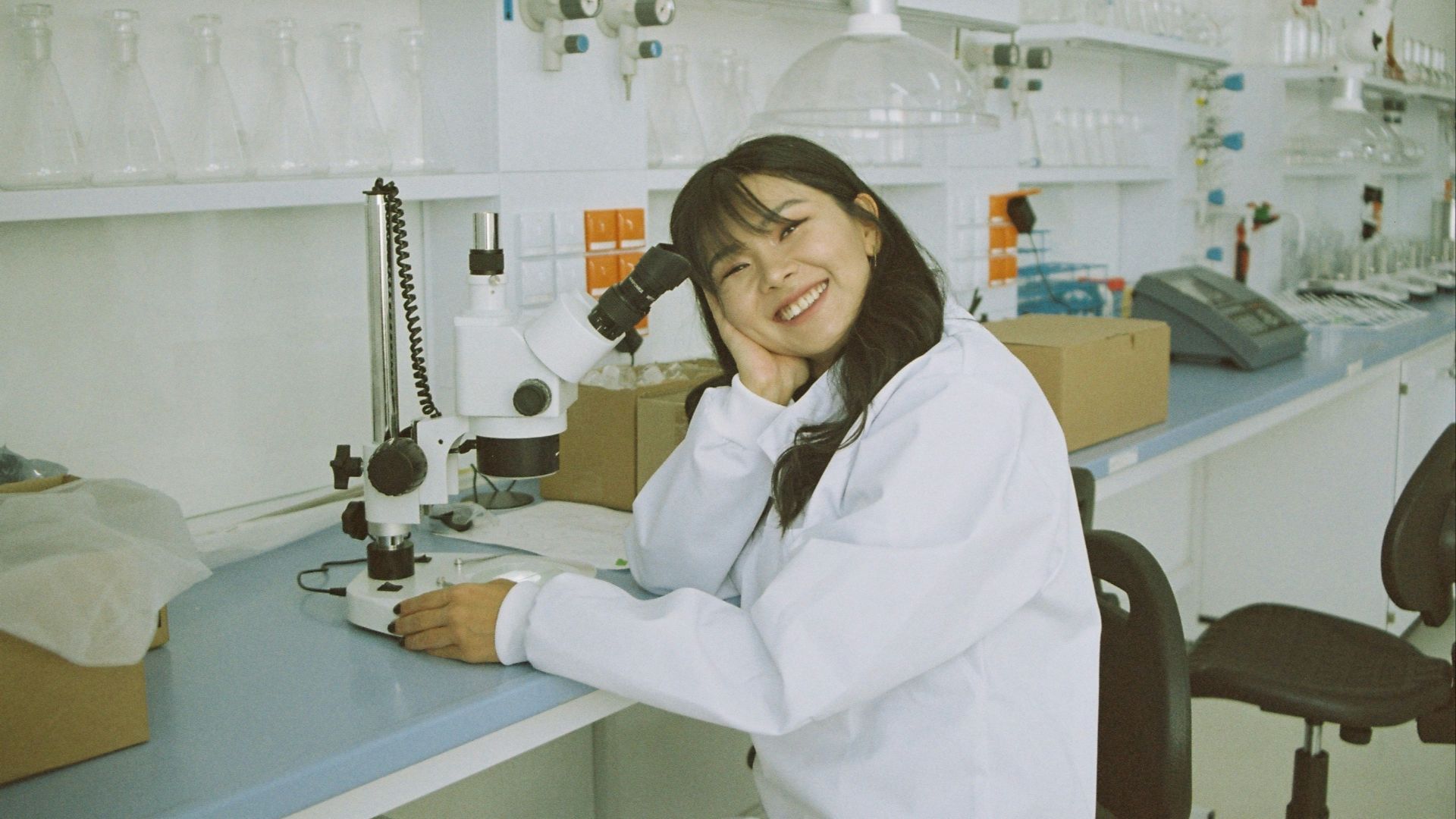 woman in white laboratory gown holding black microphone