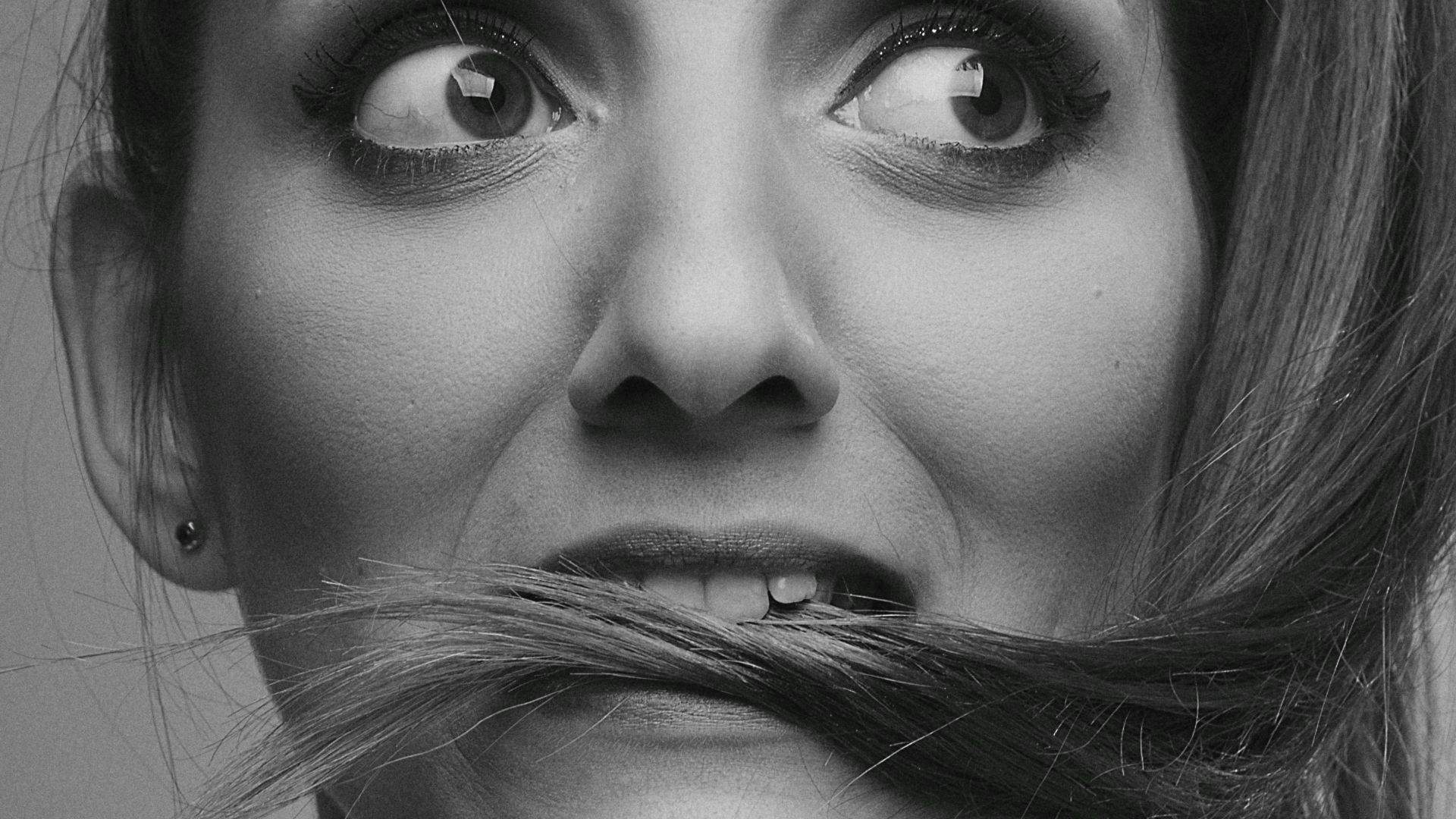 grayscale photo of woman with silver nose ring