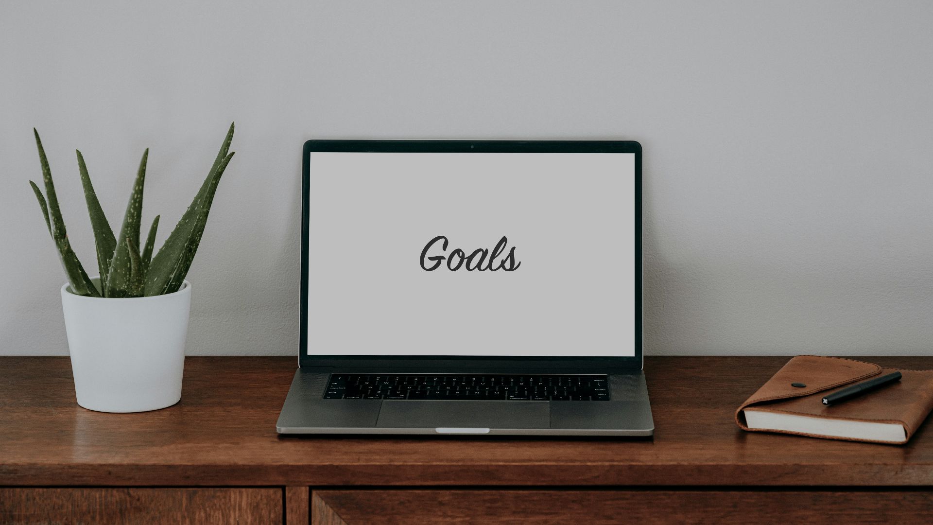 a laptop computer sitting on top of a wooden desk