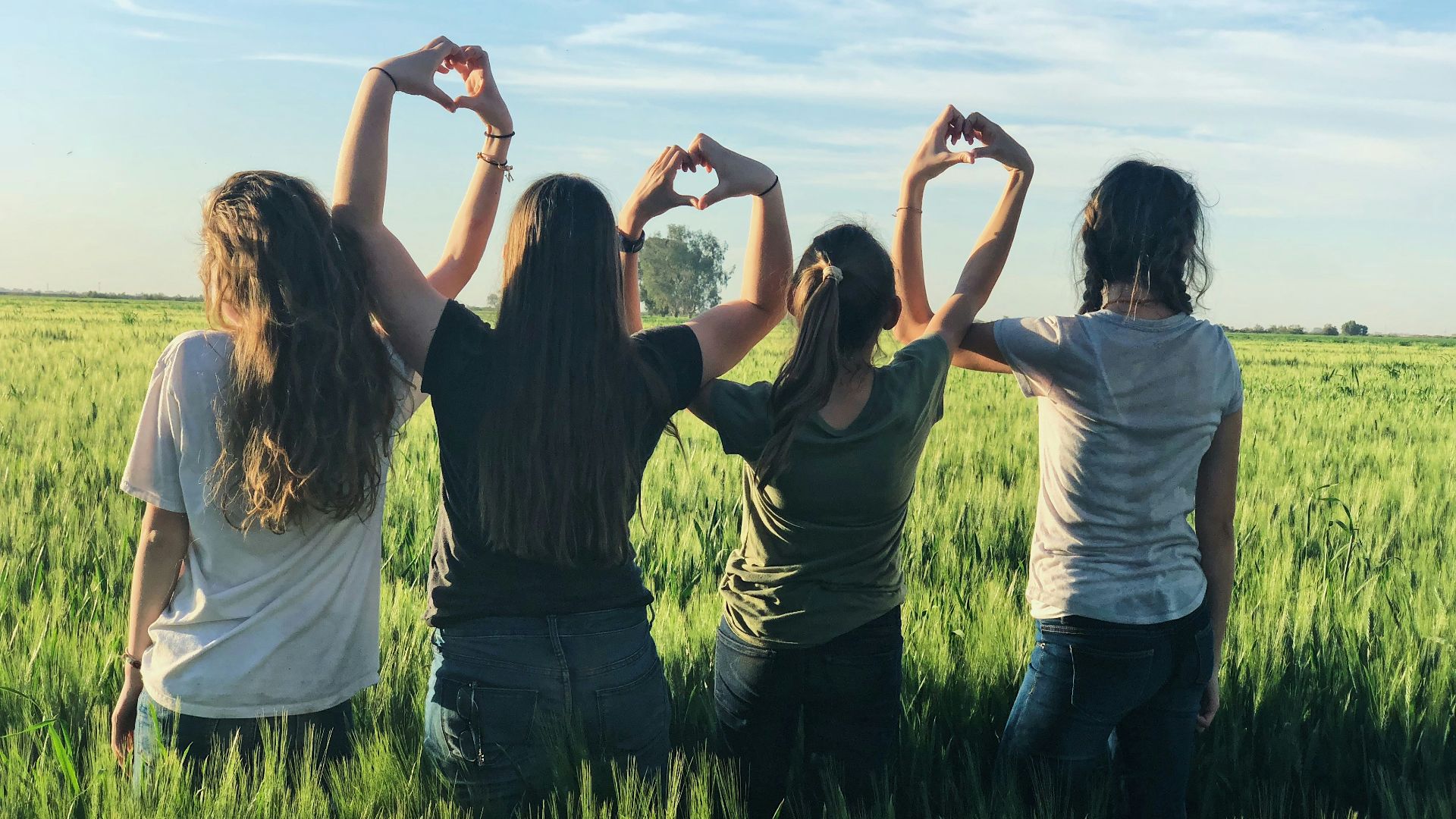 women forming heart gestures during daytime