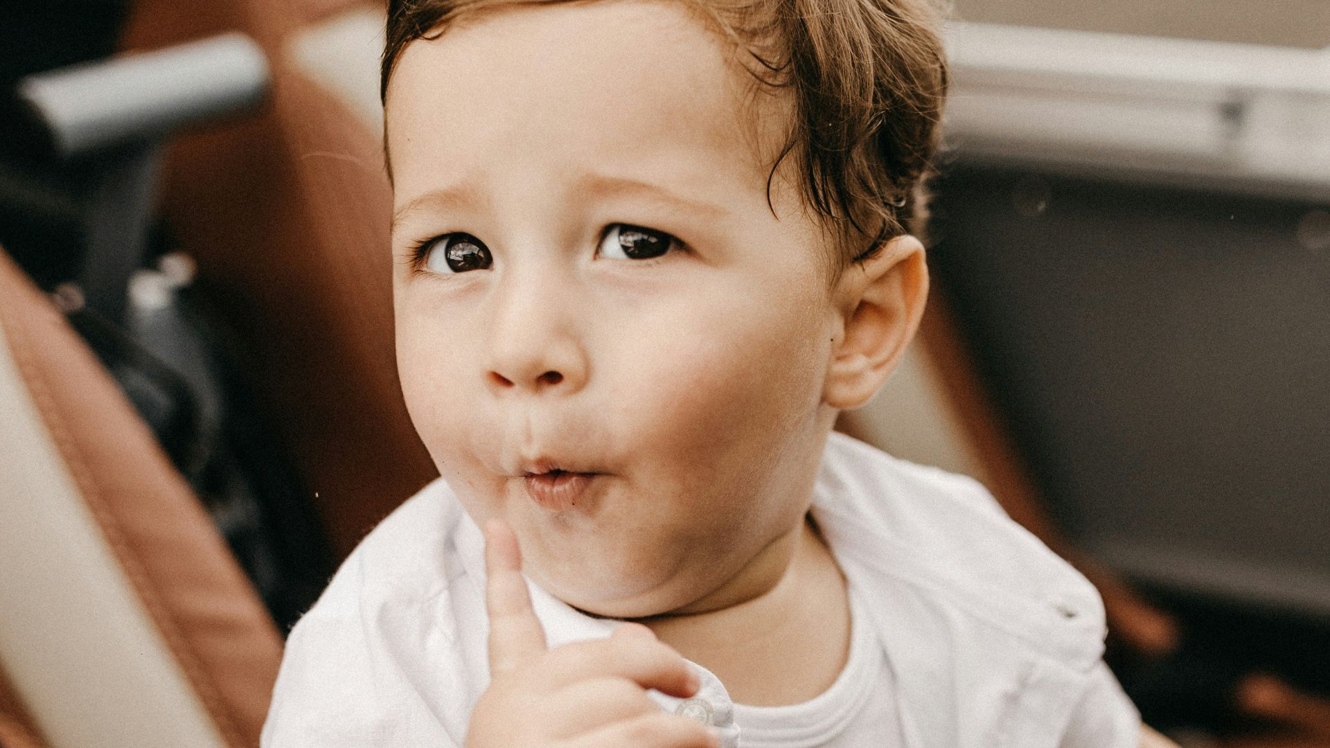 boy wearing white button-up t-shirt, white tank top and brown bottoms
