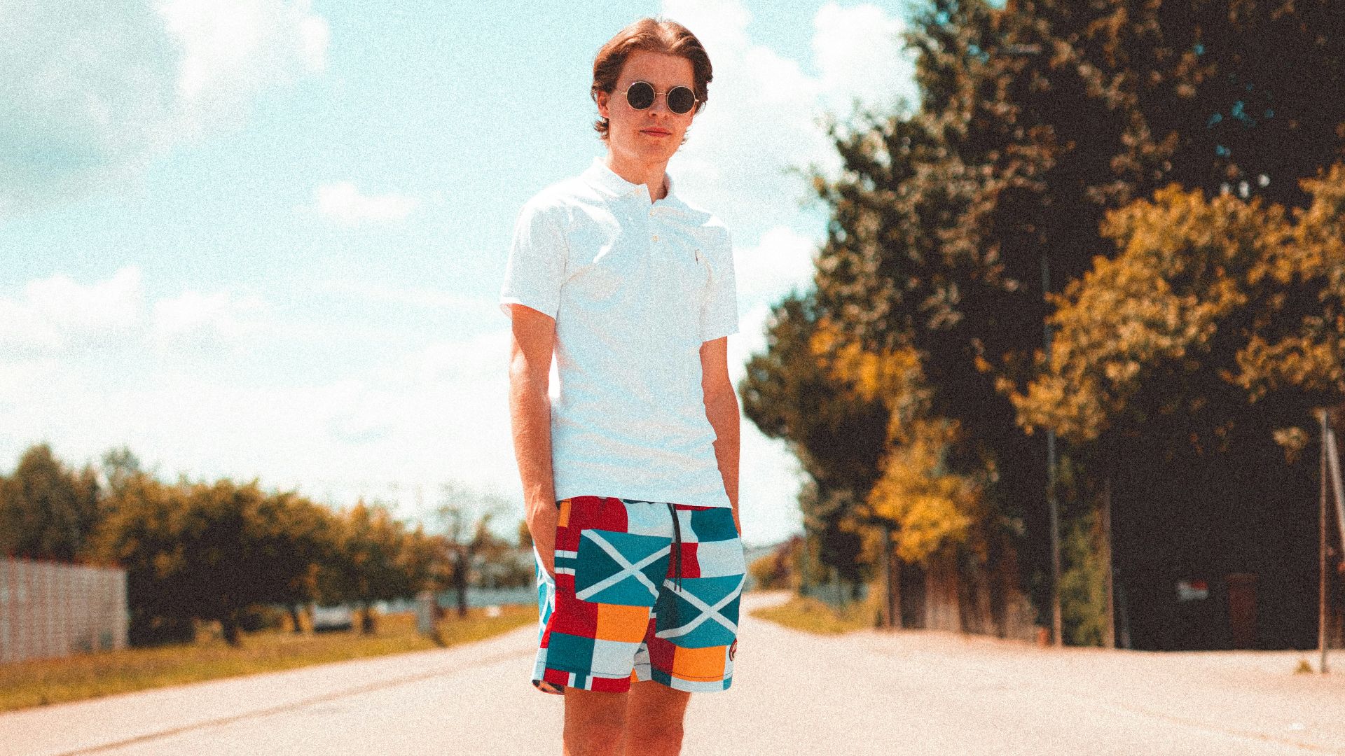 woman in white crew neck t-shirt and blue denim shorts standing on road during daytime