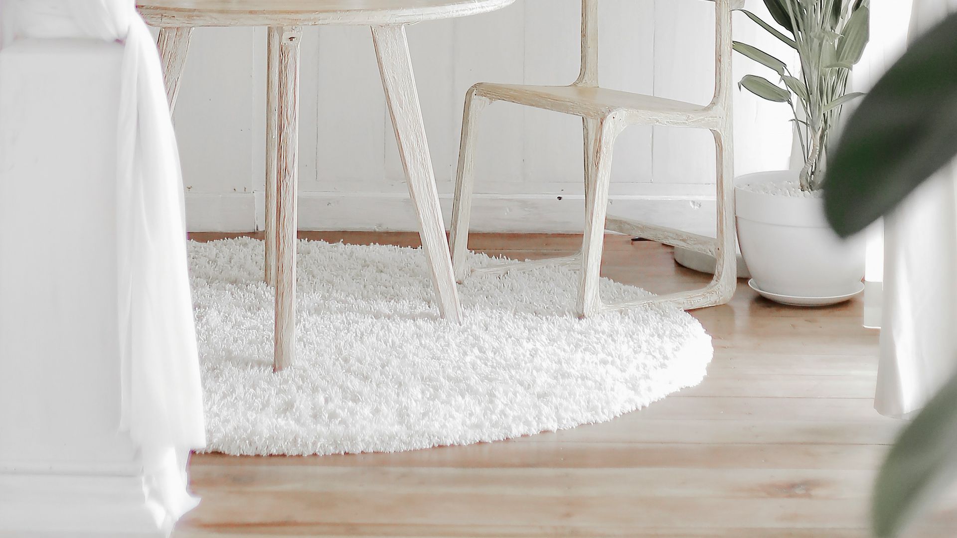 white steel chair in front round table on white rug