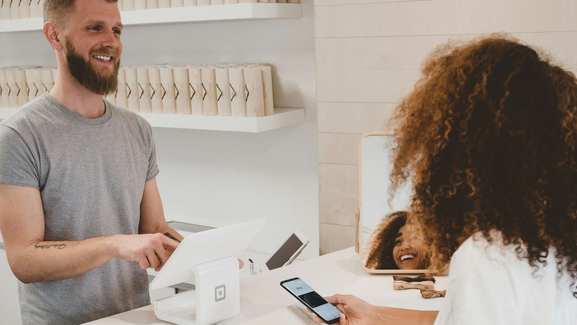 man in grey crew-neck t-shirt smiling to woman on counter