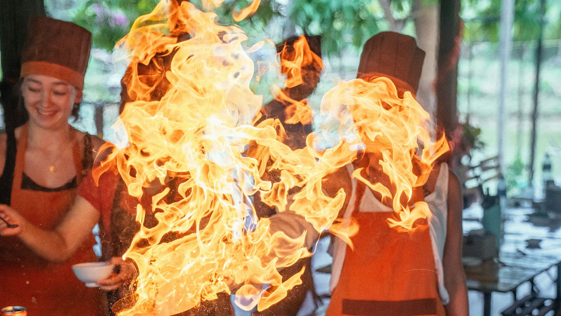 a group of people standing around a table covered in fire