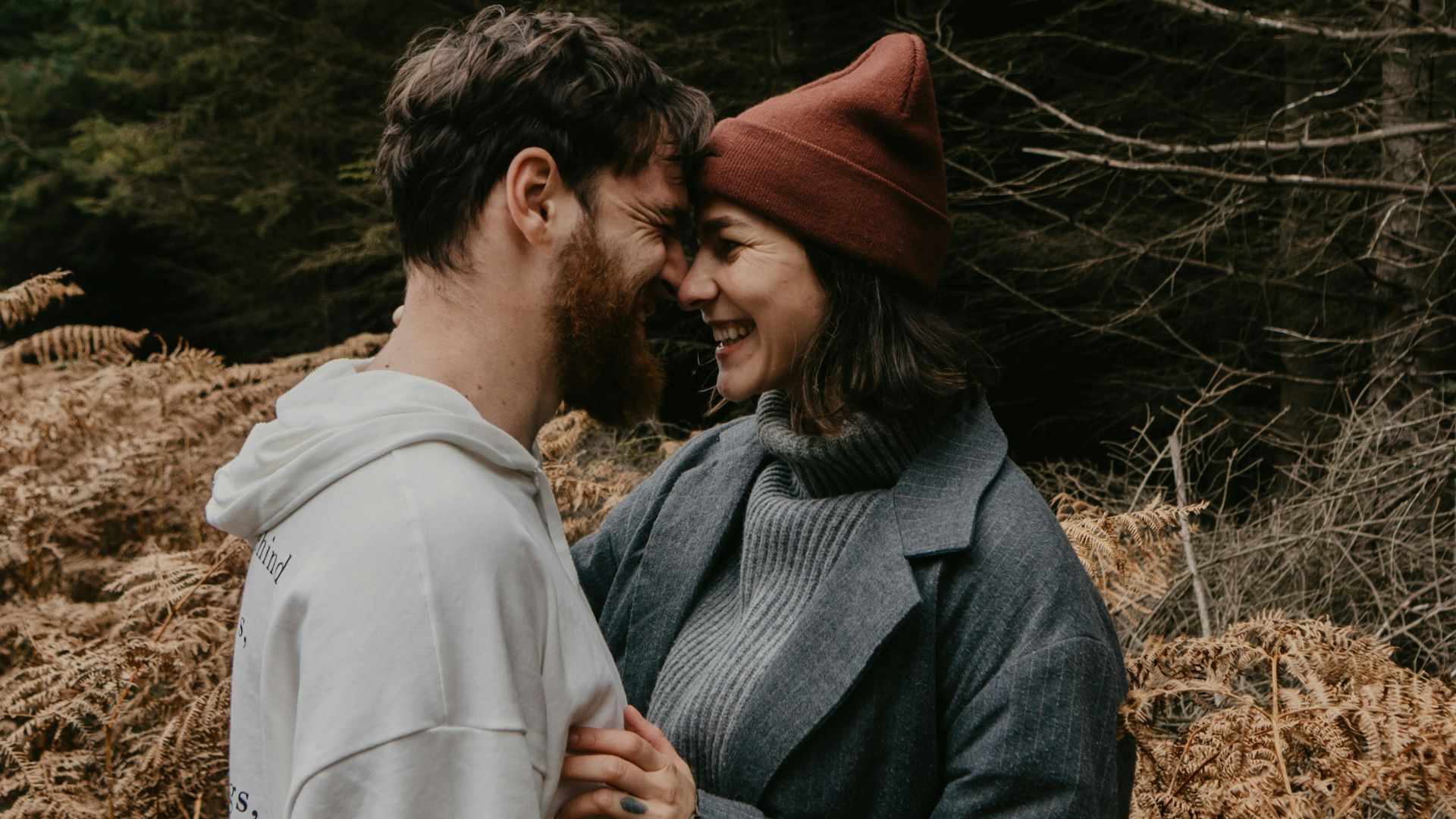 man and woman kissing on brown grass field during daytime