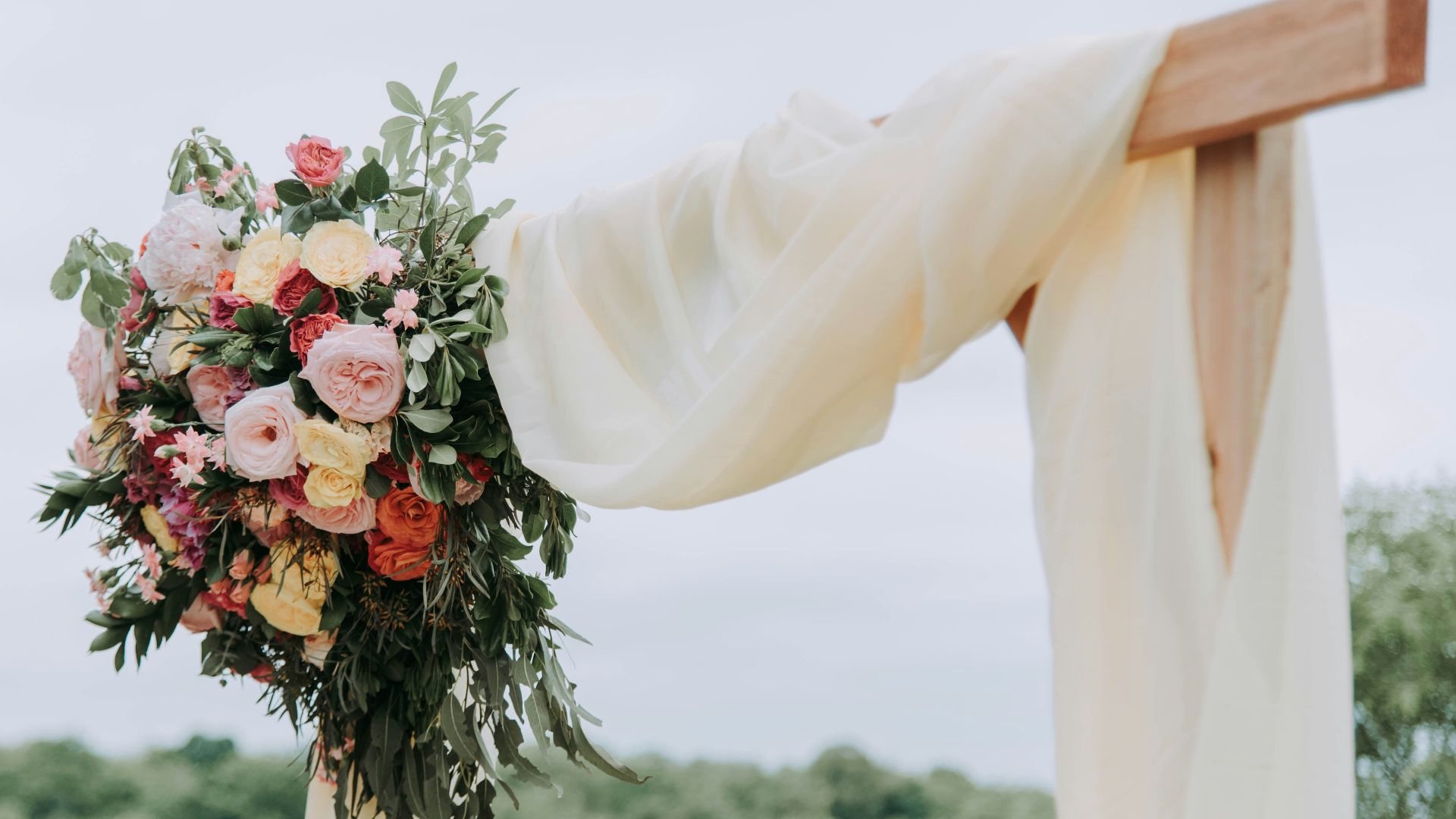 bouquet of assorted-color flowers hanged on brown plank with white textile