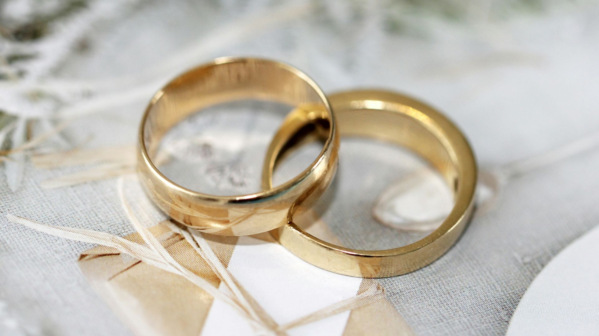 gold wedding band on white textile
