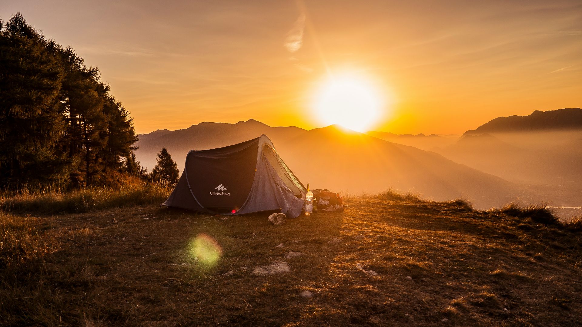 dome tent on mountain top with sun as background photo