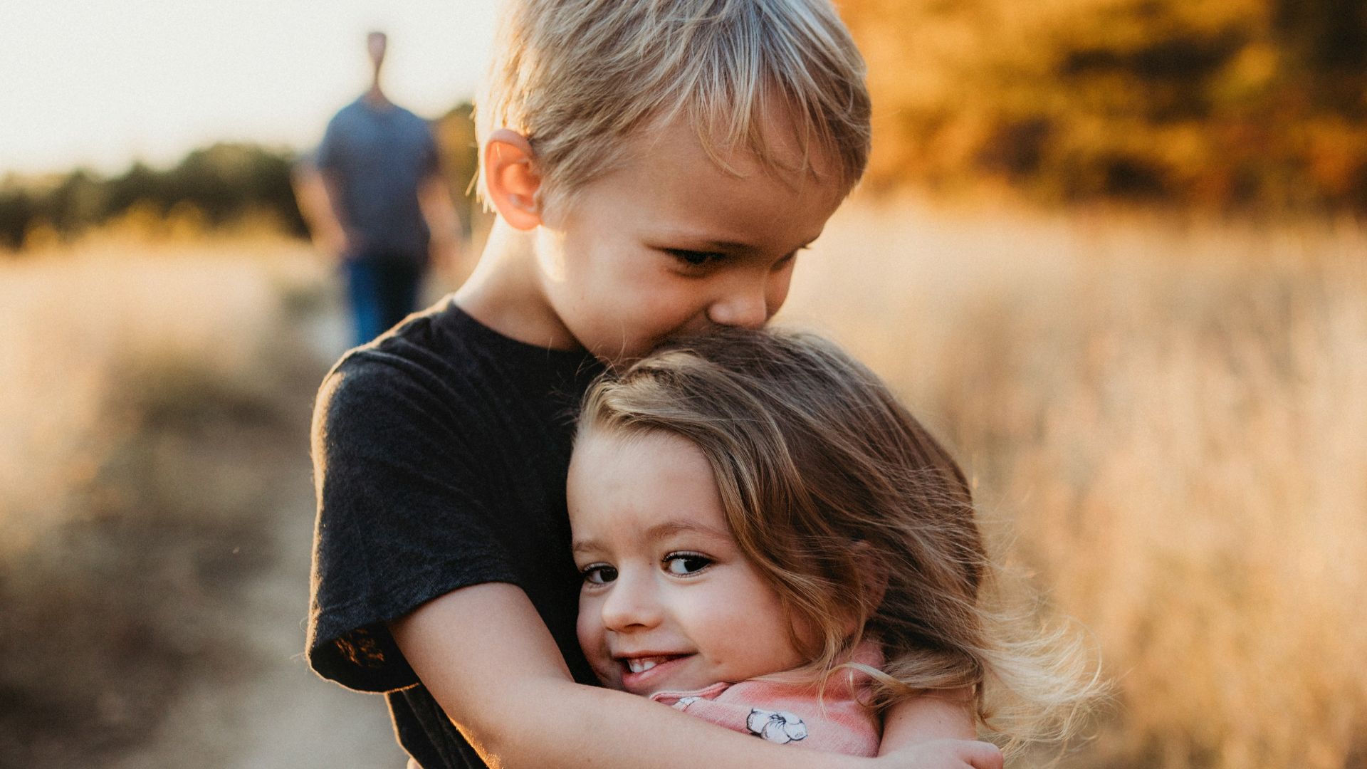 boy in black t-shirt hugging girl in red and white polka dot dress